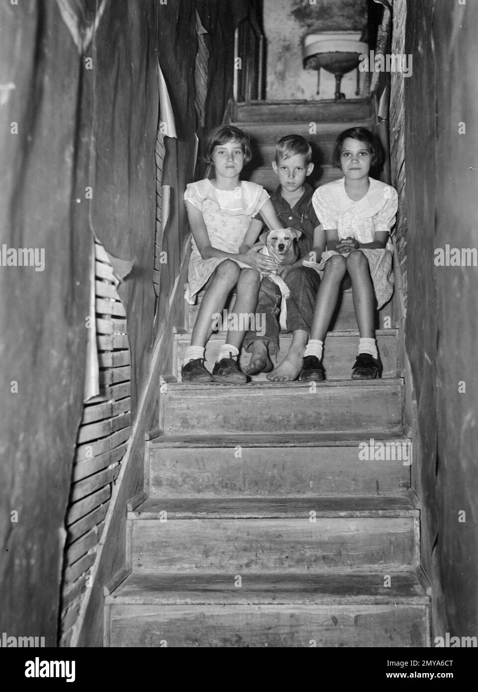 Kinder eines Migranten, der in einem heruntergekommenen Apartment House lebt. Spüle oben auf der Treppe ist nur fließendes Wasser in House, Winter Haven, Florida, USA, Arthur Rothstein, USA Neuansiedlungsverwaltung, Januar 1937 Stockfoto