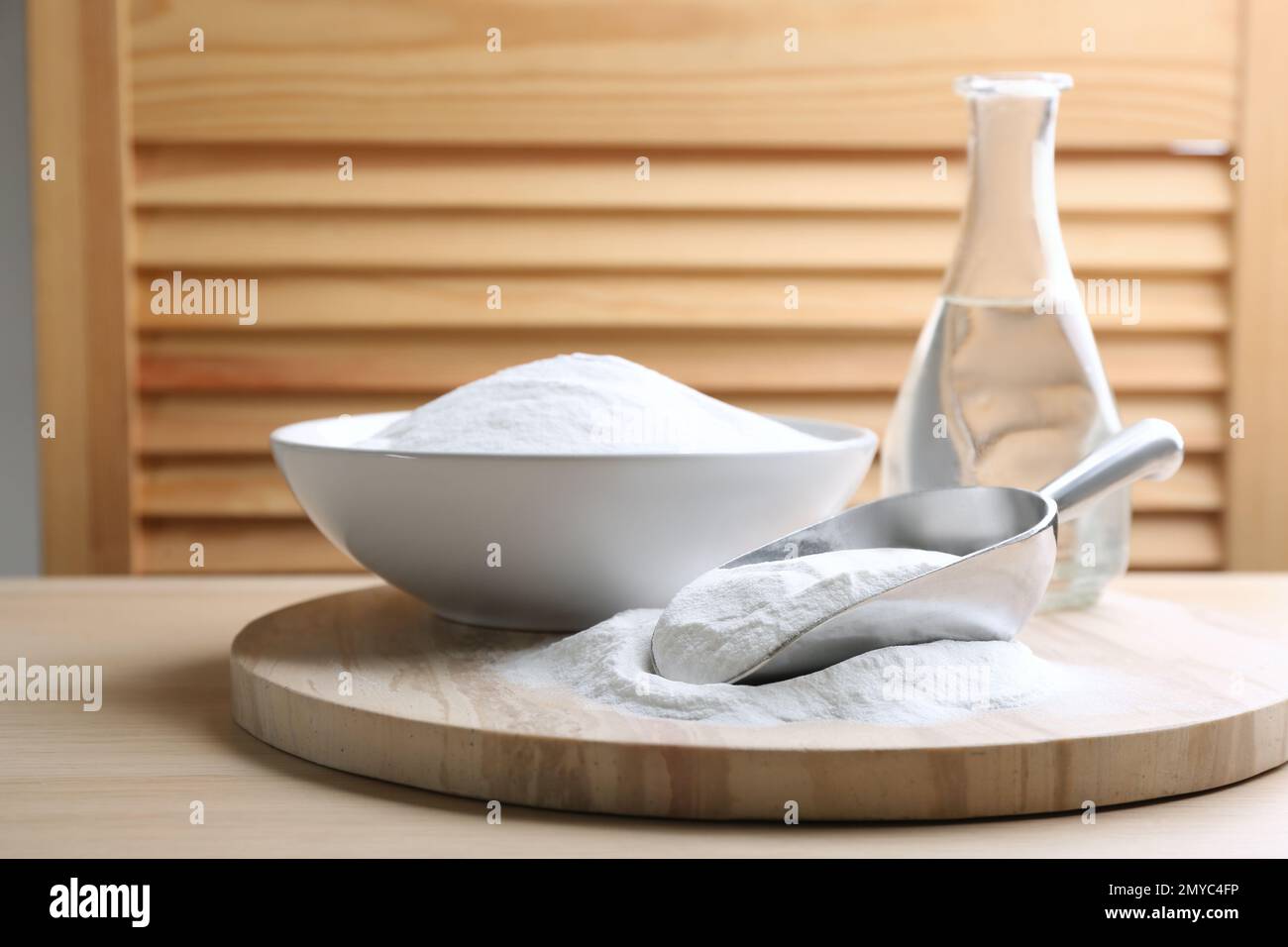Backpulver in Schaufel und Schüssel auf Holztisch Stockfoto