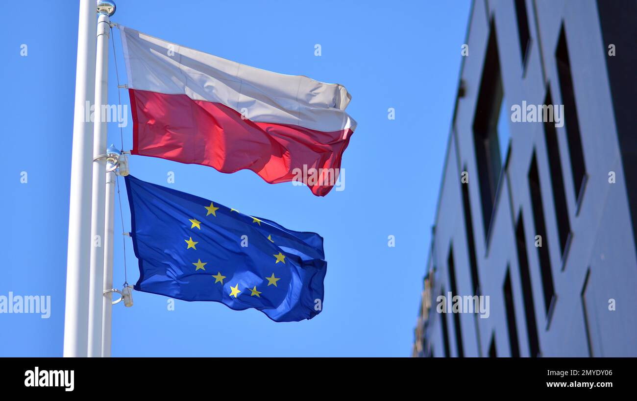 Die Flaggen Polens und der Europäischen Union winken gegen den blauen Himmel Stockfoto