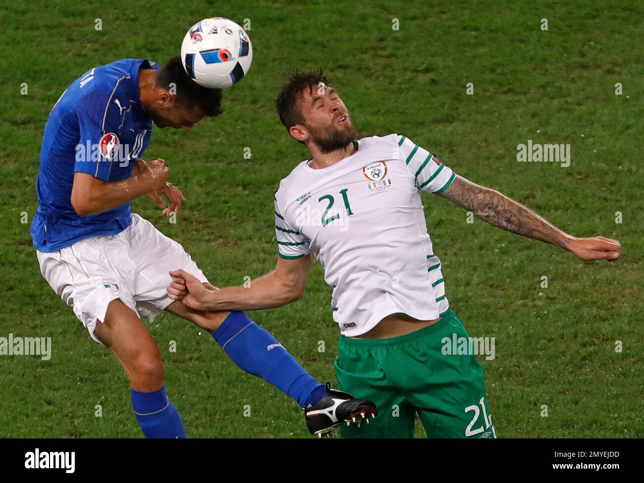 Italy's Thiago Motta jumps for the ball next to Northern Ireland's Josh Magennis during the Euro 2016 Group E soccer match between Italy and Ireland at the Pierre Mauroy stadium in Villeneuve d’Ascq, near Lille, France, Wednesday, June 22, 2016. (AP Photo/Darko Vojinovic) Stockfoto