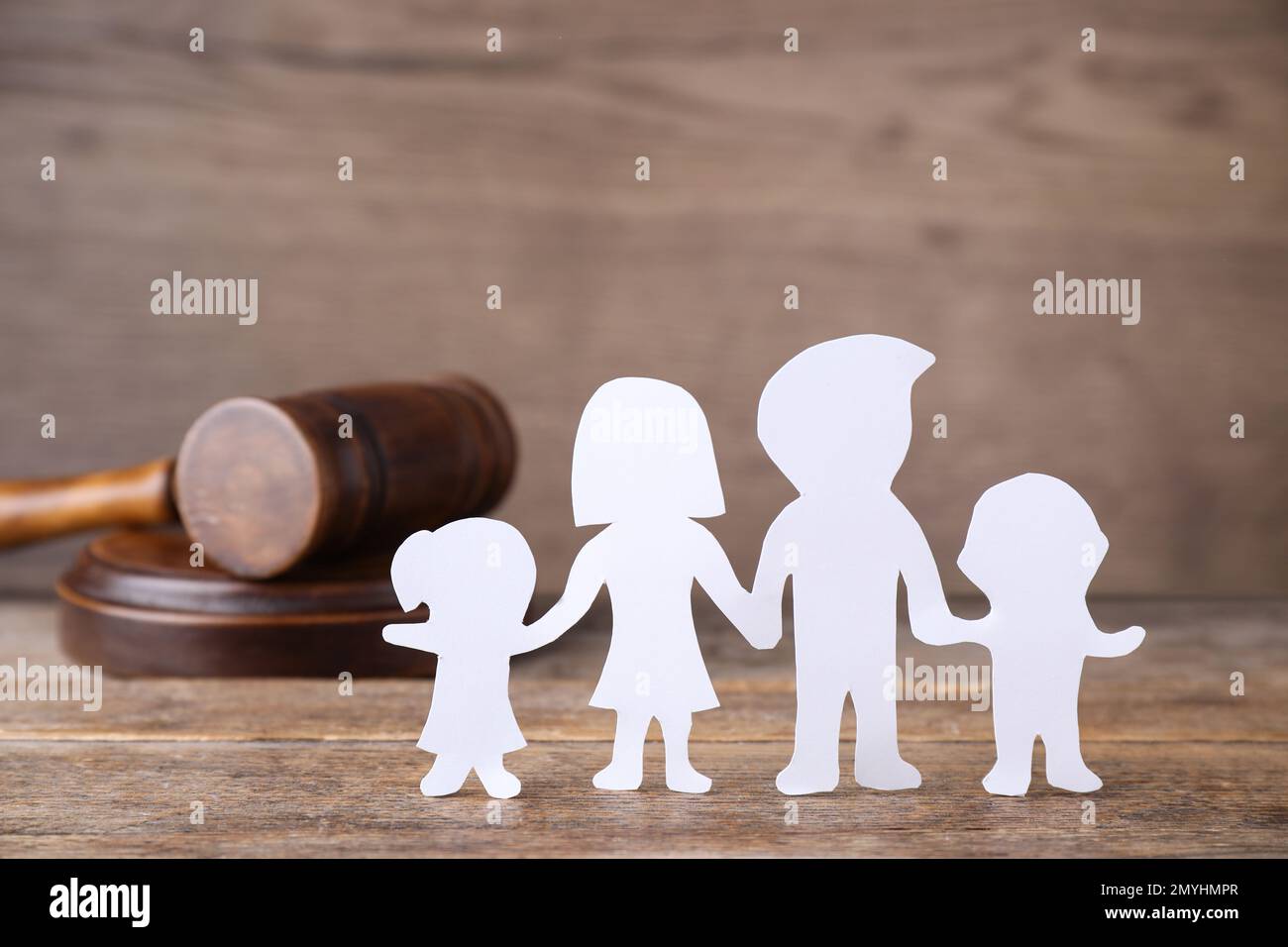 Familienfigur und Hammer auf Holztisch. Familienrechtsbegriff Stockfoto