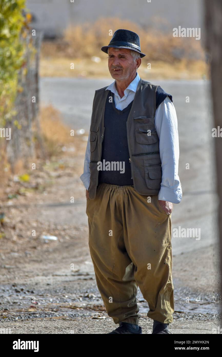 Ein kurdischer Mann, der auf einer Dorfstraße steht, mit den Händen in den Taschen Stockfoto