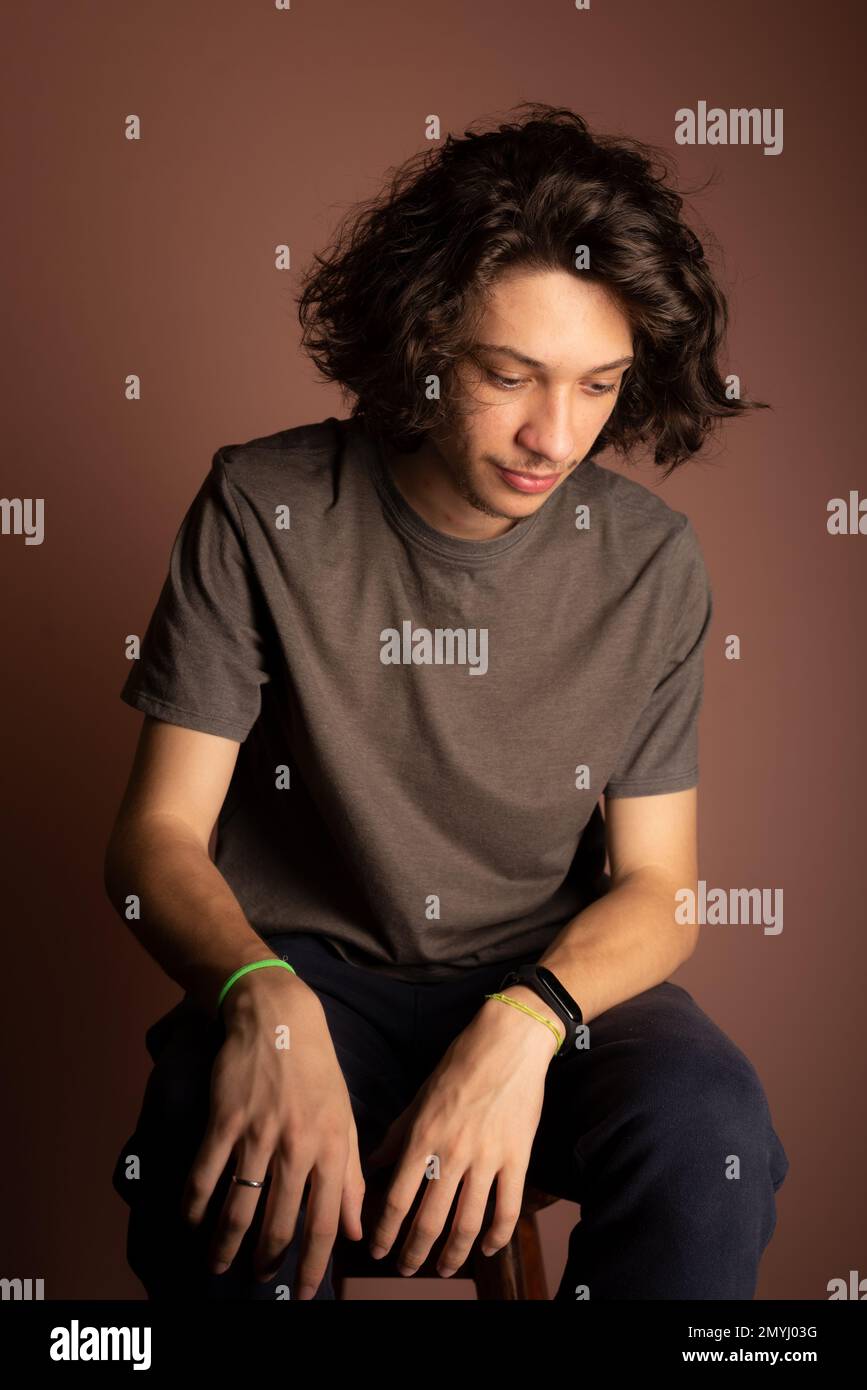 Porträt eines gutaussehenden und rücksichtsvollen jungen Mannes vor Bisque Color Hintergrund. Stockfoto