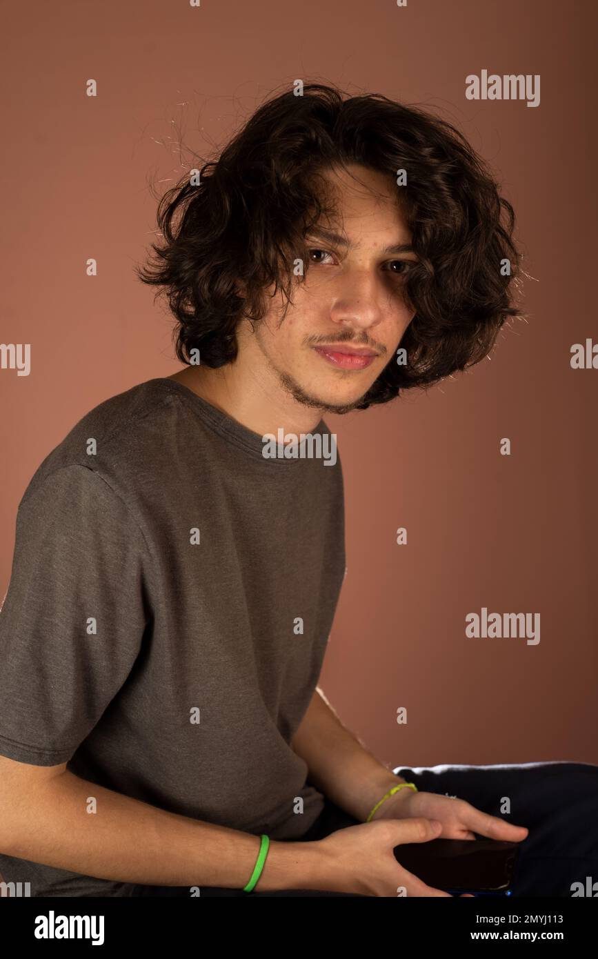 Studioporträt eines jungen, gutaussehenden Mannes. Isoliert vor Bisque-Hintergrund. Stockfoto