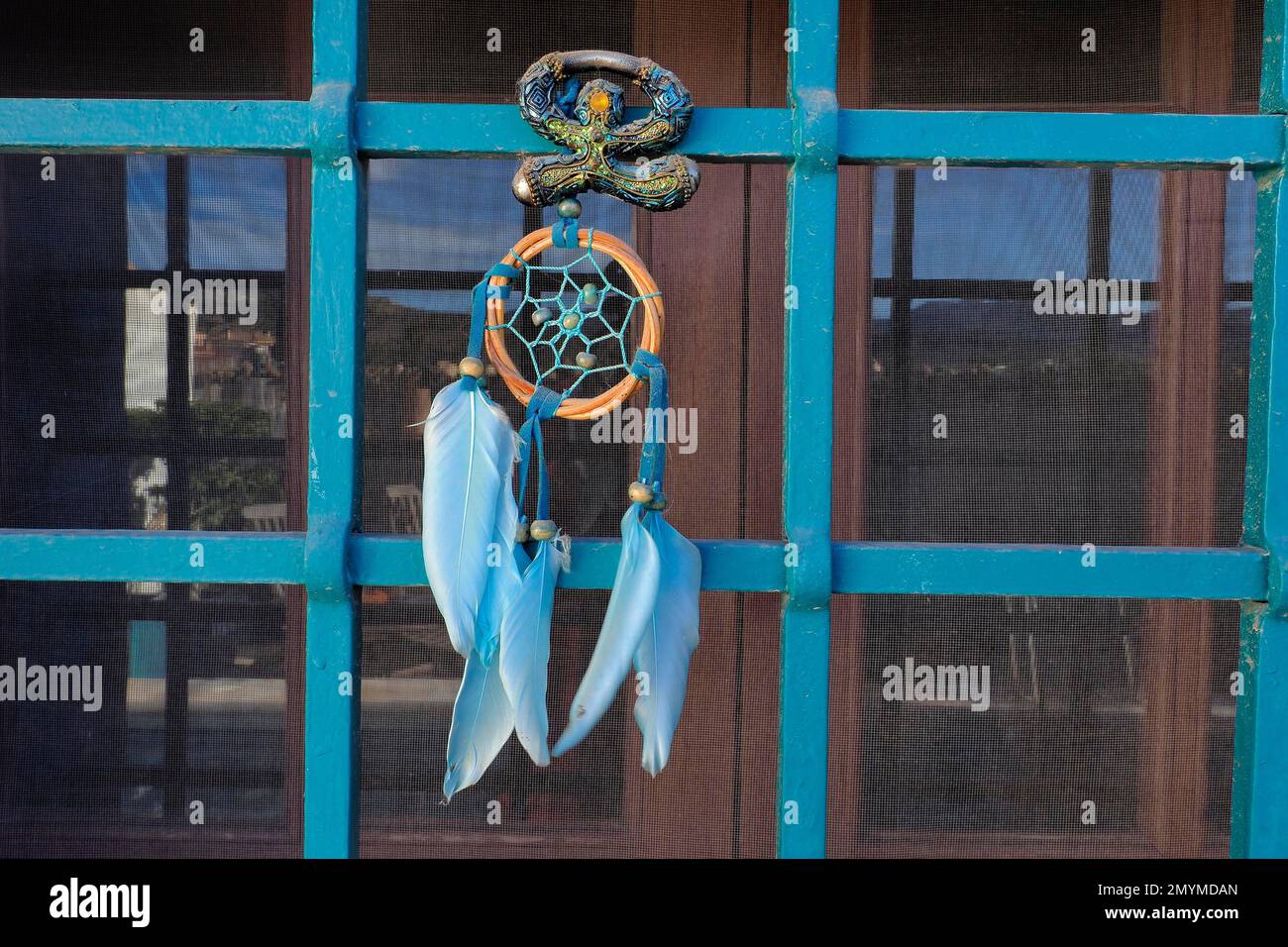 Andalusischer Glücksbringer Indalo und Dreamcatcher am Iron Grille of Window Stockfoto