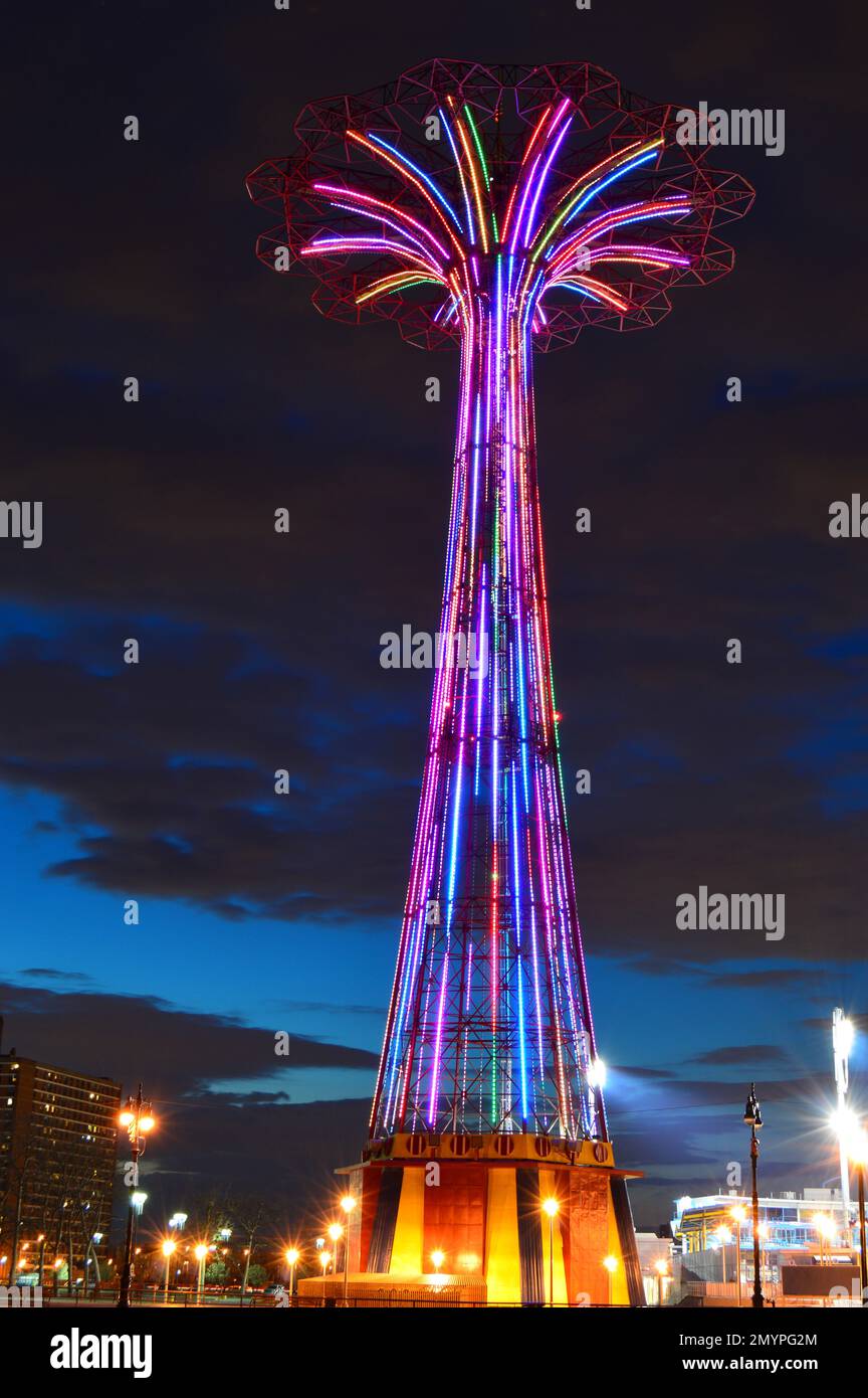 Der ehemalige Fallschirmsprung wird auf Coney Island beleuchtet und in der Dämmerung mit bunten Neonlichtern beleuchtet Stockfoto