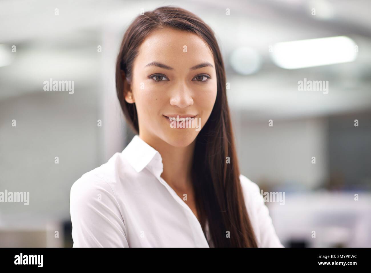 Sie passt perfekt zu Ihrem Unternehmen. Porträt einer attraktiven jungen Geschäftsfrau, die im Büro steht. Stockfoto