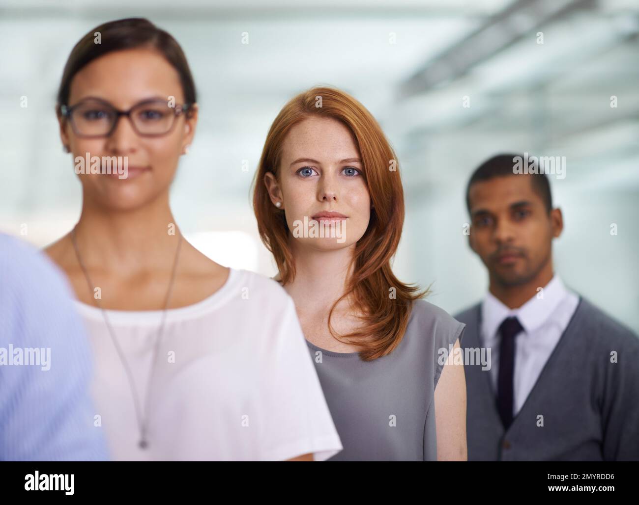 Gemeinsam können wir mehr erreichen. Porträt einer jungen Geschäftsfrau, die unter ihren Kollegen in einem Büro steht. Stockfoto