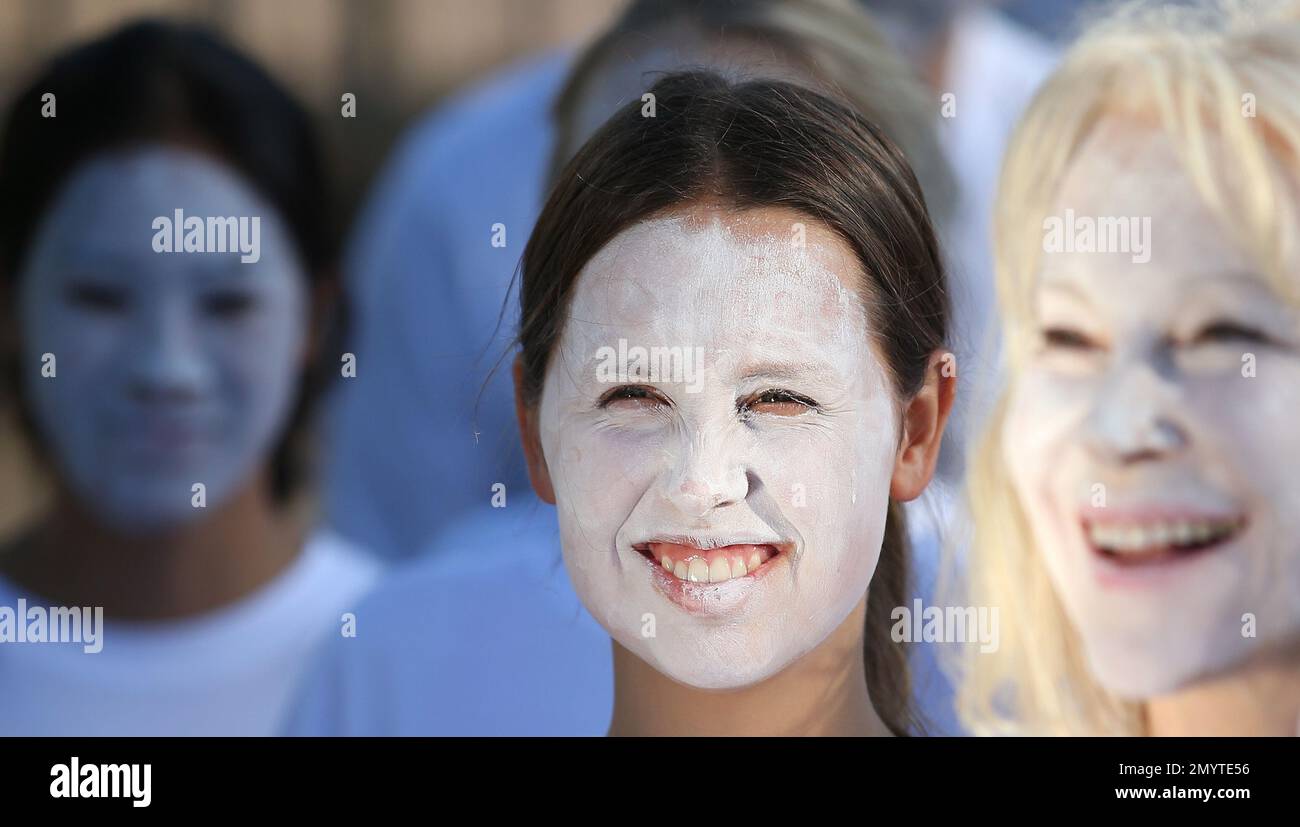 Demonstrators from the environmental group Greenpeace paint their faces