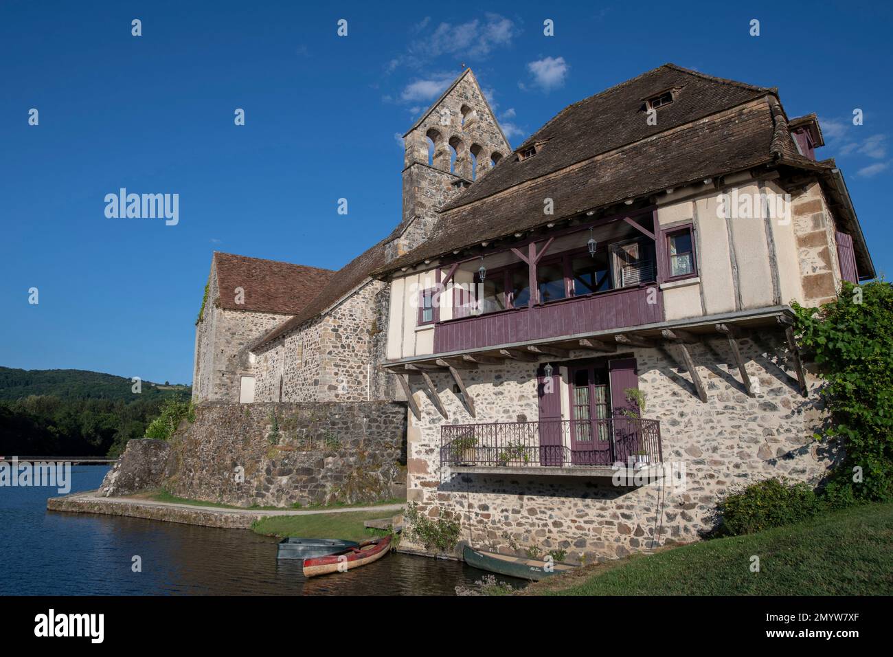 Fluss und mittelalterliche Kirche und Haus, Beaulieu-sur-Dordogne, Corrèze, Nouvelle-Aquitaine, Frankreich Stockfoto