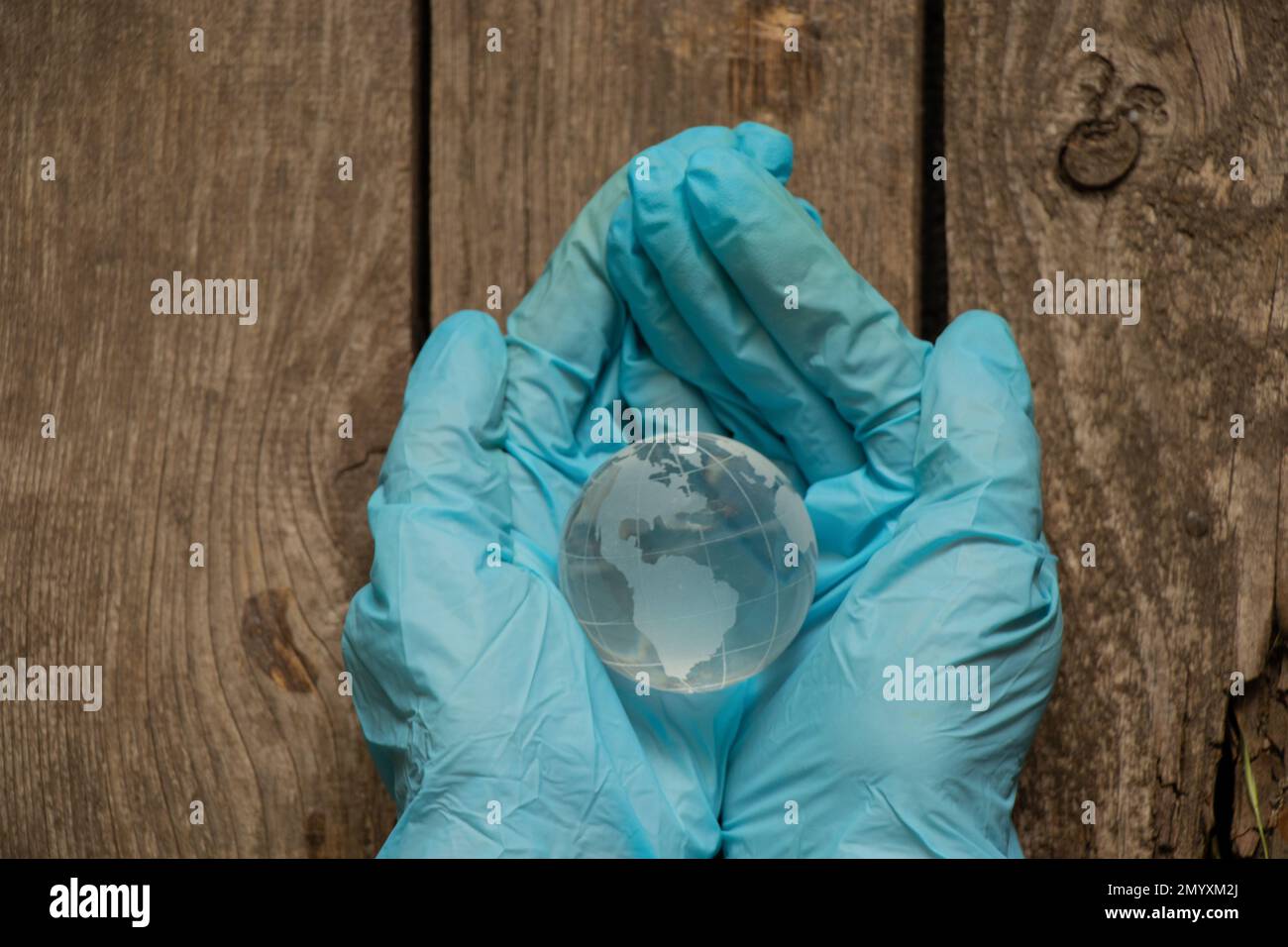Hände in medizinischen Handschuhen mit einem Globus Stockfoto