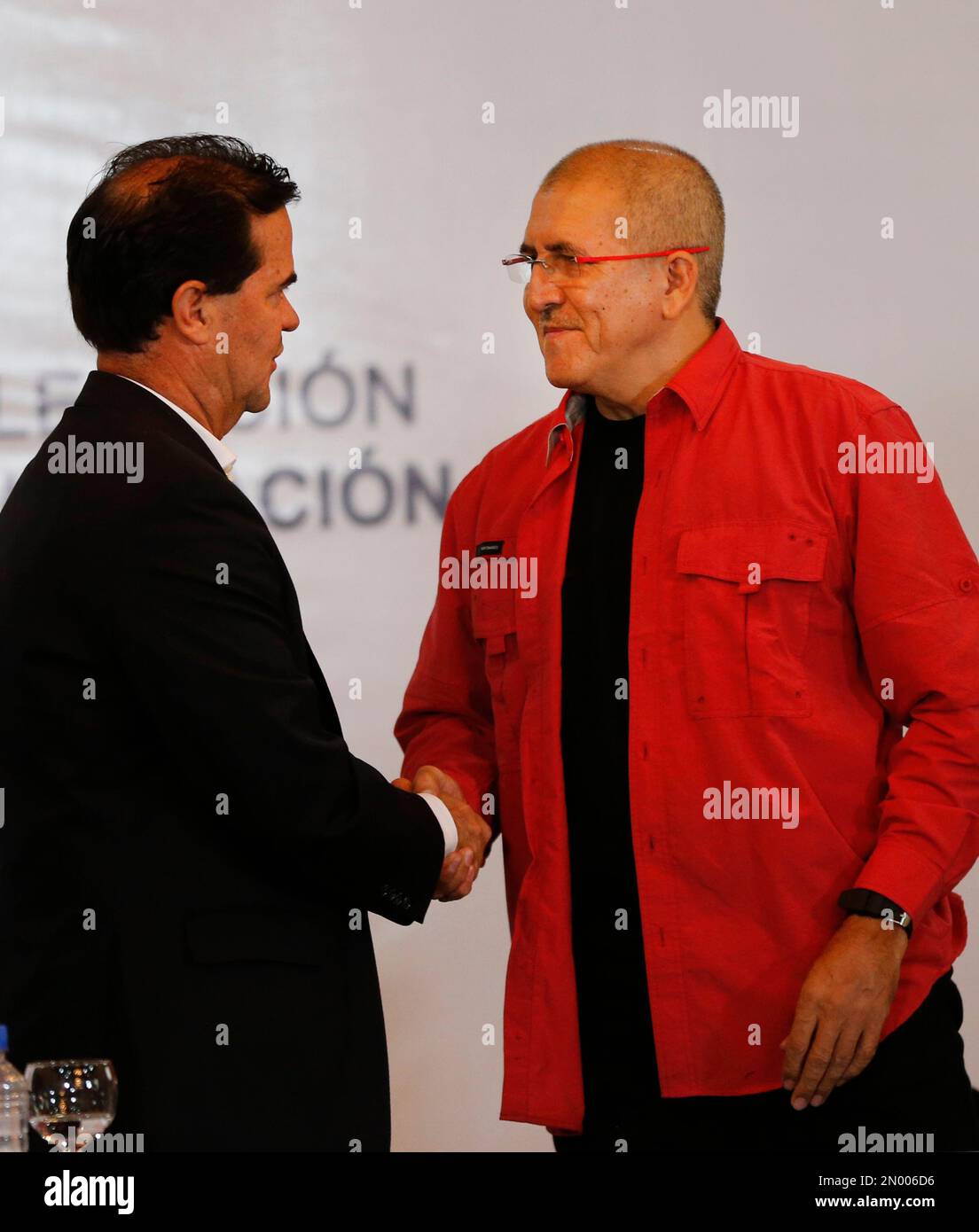 Frank Pearl, head of Colombia's peace negotiation team, left, shake hands with Antonio Garcia, chief negotiator of the National Liberation Army, or ELN, during a signing agreement to start peace talks, in Caracas, Venezuela, Wednesday, March 30, 2016. The formal peace talks with the ELN, the country's second-largest rebel group, heightens expectations for a definitive end to a half-century of political violence in the Andean nation. (AP Photo/Ariana Cubillos) Stockfoto