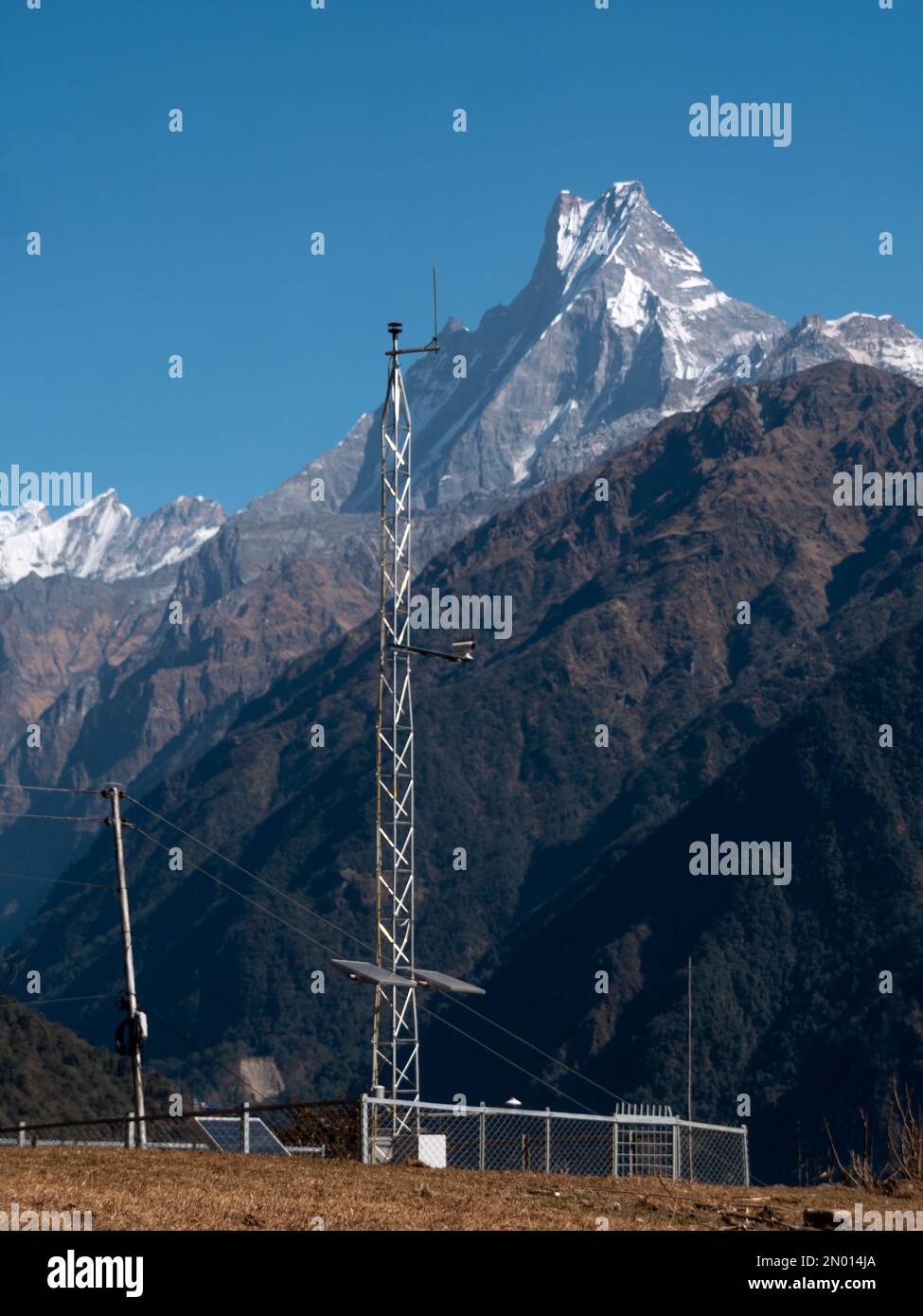 Vertikale Ansicht des Telekommunikationsturms, des Waldes und des Mt. Fishtail Machapuchare Himalaya, Annapurna Circuit Trek. (Nepal). Stockfoto