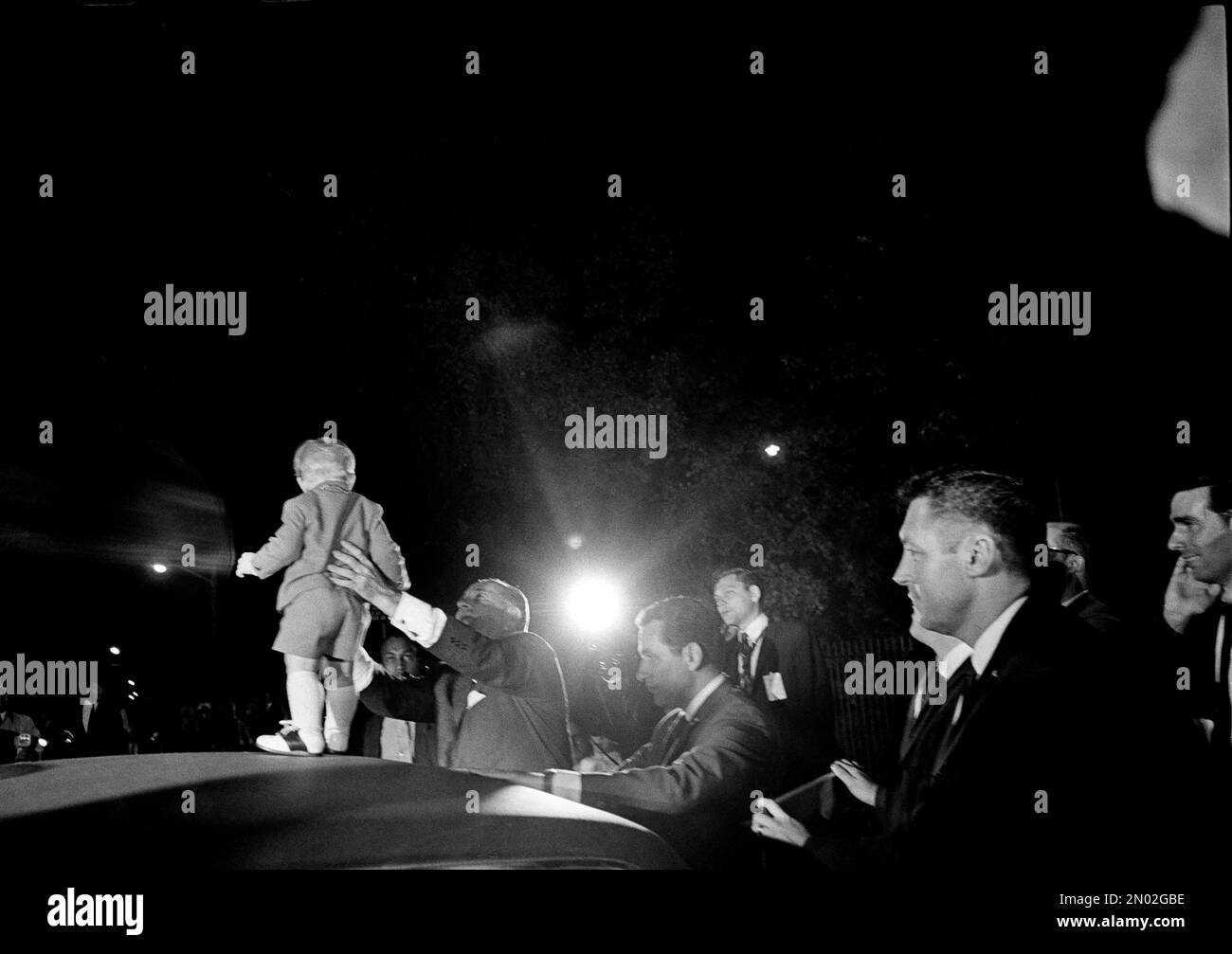 Little 15-month-old Lyn Nugent, grandson of President Johnson, lower left, is proudly displayed by "grandpa" atop the president's car after a visit at the home of former President Harry Truman in Independence, Mo., Oct. 11, 1968. Lyn is the son of Luci Baines Johnson (Mrs. Pat Nugent), the president's daughter. President Johnson paid a surprise quickie visit to the Trumans. (AP Photo/William P. Straeter) Stockfoto