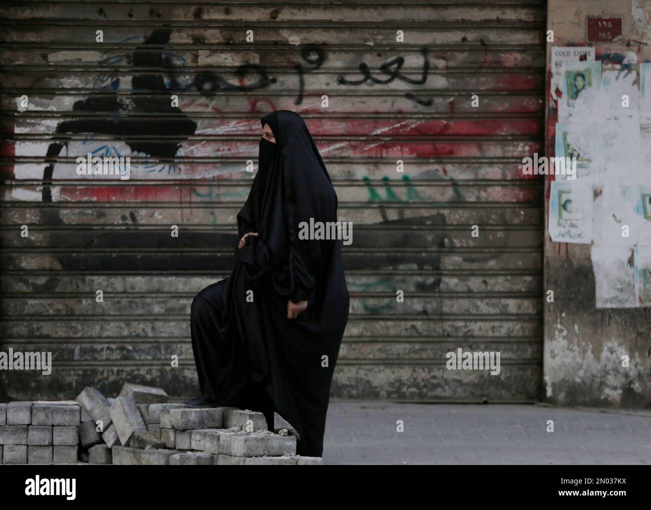 A Bahraini anti-government protester looks toward riot police firing tear gas during clashes in Daih, Bahrain, Monday, March 14, 2016. Bahraini police detained a political activist and her year-old son on Monday in an operation that came on the fifth anniversary of Saudi and Emirati soldiers putting down Arab Spring-inspired protests in the tiny island kingdom.(AP Photo/Hasan Jamali) Stockfoto