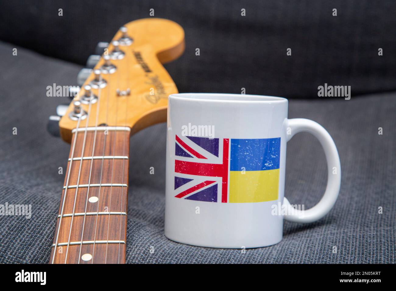 Unterstützung für die Ukraine. Musiker unterstützen ukrainische Hilfe. Gitarre und Kaffeetasse. Ukraine Relief, DEZ, Rotes Kreuz Fonds.Ukraine Flagge, Union Jack Stockfoto