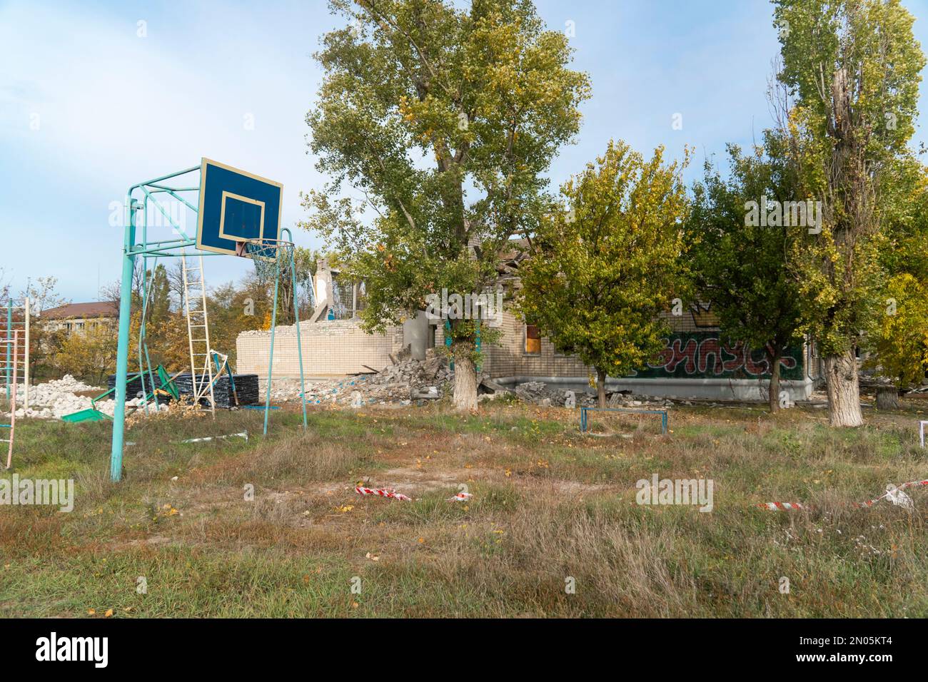 Stadion der zerstörten Schule. Krieg in der Ukraine. Russische Invasion der Ukraine. Zerstörung der Infrastruktur. Terror der Zivilbevölkerung Stockfoto