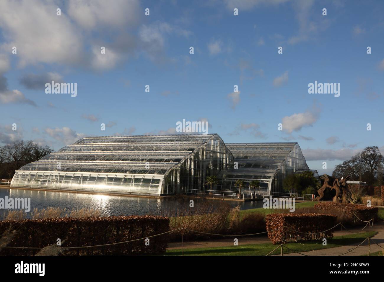 Tanzende Hasen Skulptur von Sophie Ryder vor Glasshouse Wisley RHS Gardens Surrey England Stockfoto