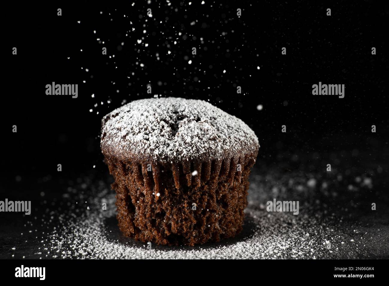 Schlichter Schuss eines Schokoladen-Muffins mit Puderzucker. Makro-Seitenaufnahme Stockfoto