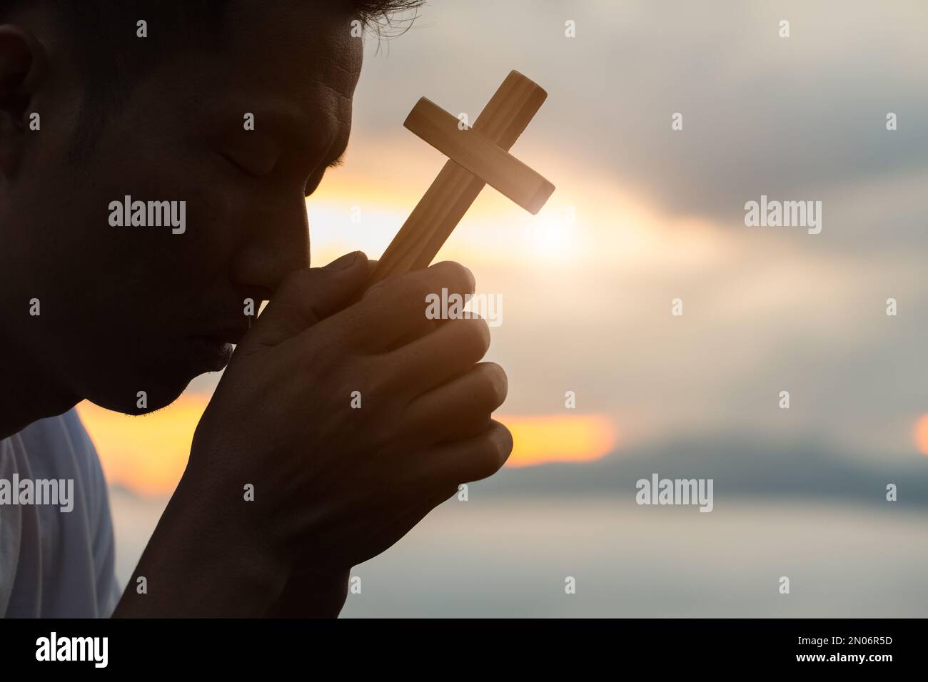 Die menschliche Hand hält das Kreuz. Eucharistische Therapie, Segne Gott, Der Der Regnerischen Katholischen Osterszene Hilft. Christlicher Konzepthintergrund. Stockfoto