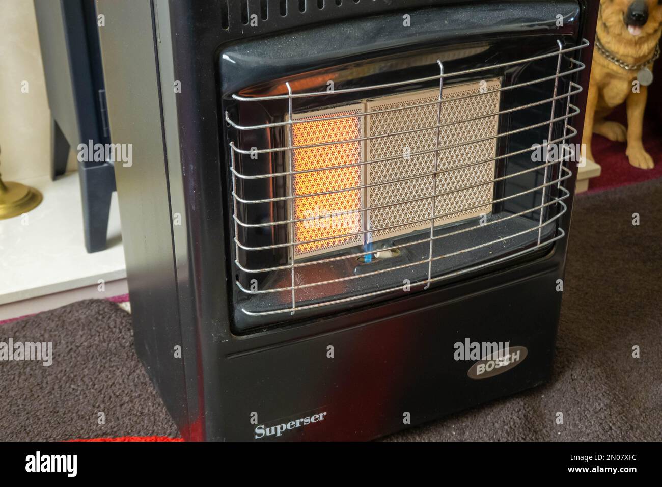 Mobiles Heizgerät, das mit Butangas betrieben wird, wobei ein Teil Wärme in einem Wohnzimmer in Großbritannien abgibt Stockfoto