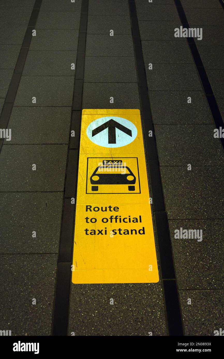 Wegbeschreibung zum offiziellen Taxistand auf dem Gehweg des internationalen Flughafens Schiphol, Niederlande Stockfoto