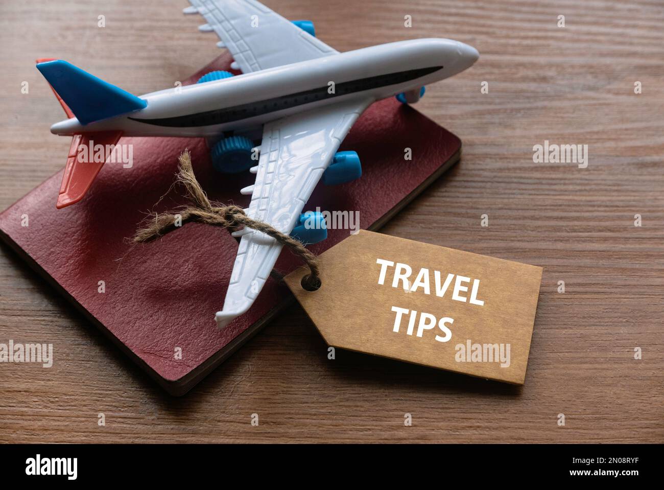 Ein Reisepass, ein Spielzeugflugzeug und ein Schild mit Reisetipps. Stockfoto