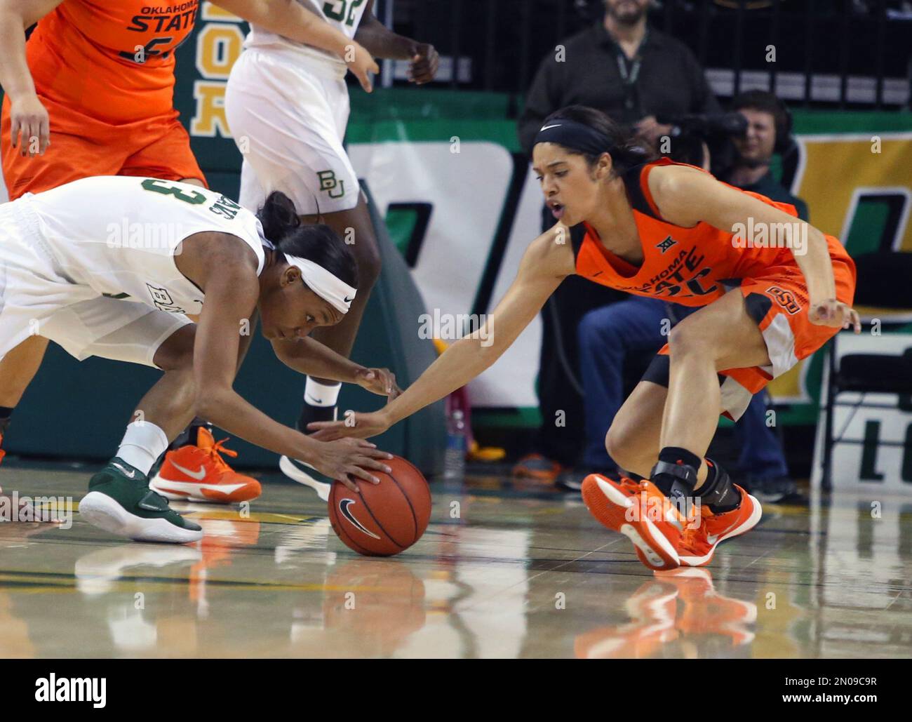 Oklahoma State guard Brittney Martin (22), right, reaches for a loose ball with Baylor forward Nina Davis, in the first half of an NCAA college basketball game, Wednesday, Feb. 17, 2016, in Waco, Texas. (AP Photo/Jerry Larson) Stockfoto