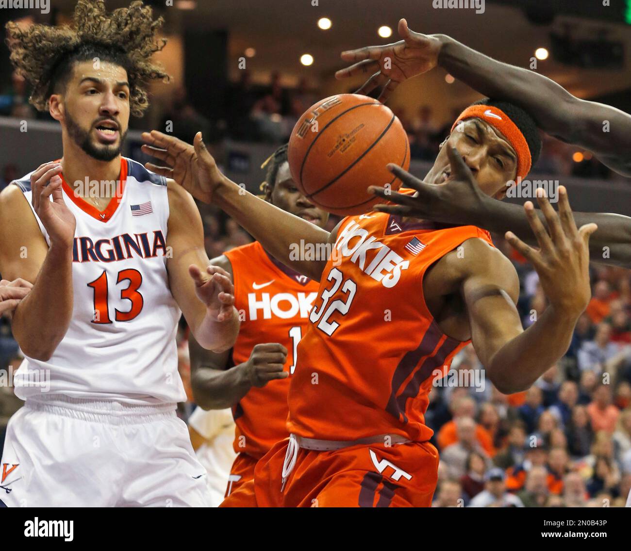 Virginia forward Anthony Gill (13) and Virginia Tech forward Zach LeDay (32) reach for a rebound during the first half of an NCAA college basketball game in Charlottesville, Va., Tuesday, Feb. 9, 2016. (AP Photo/Steve Helber) Stockfoto