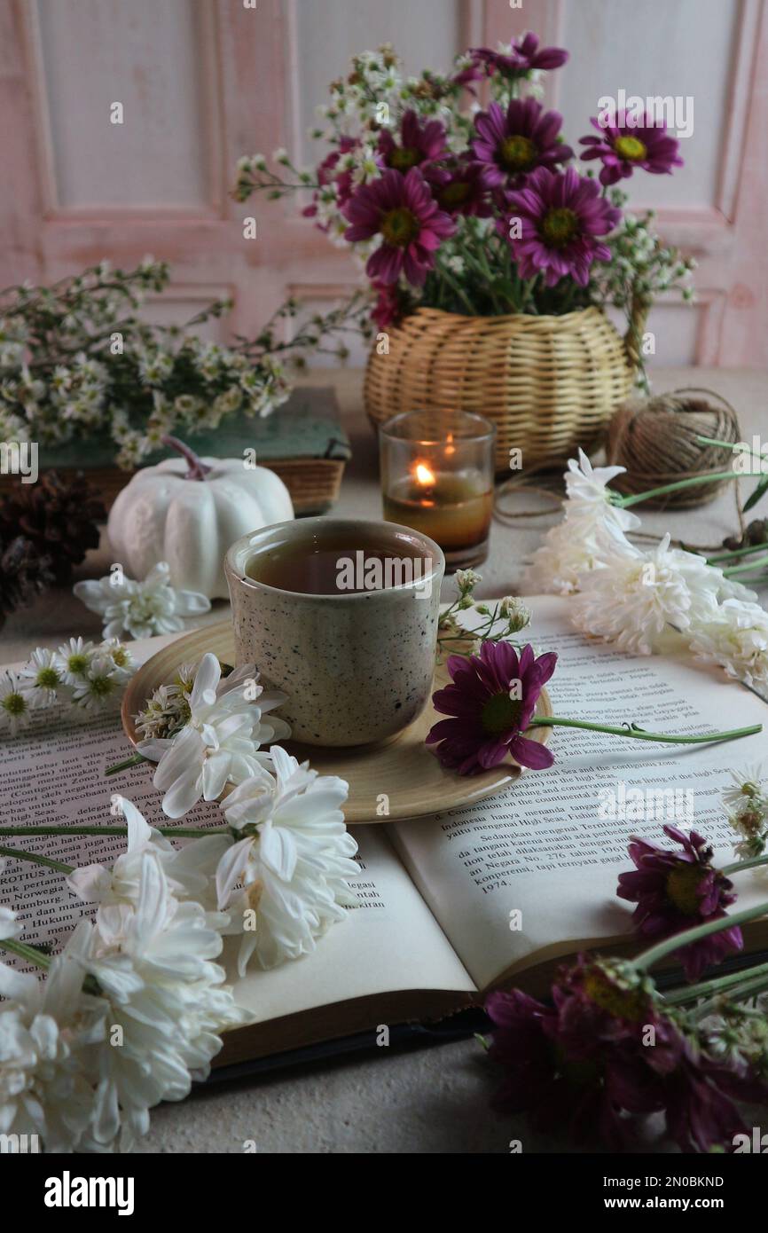 Eine Tasse Tee unter verstreuten Blumen Stockfoto