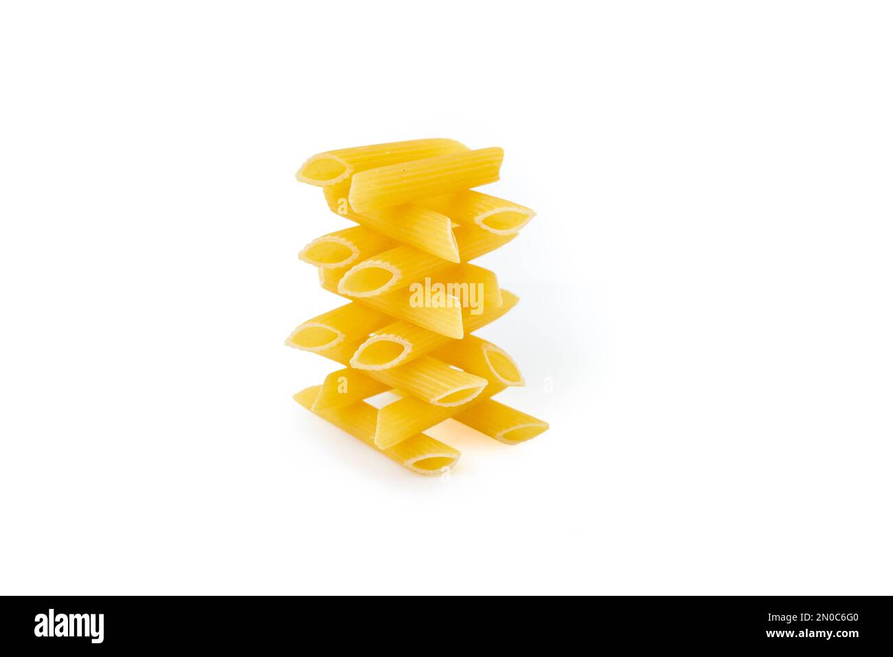 Gestapelter Penne Pasta Tower isoliert auf weißem Hintergrund Stockfoto