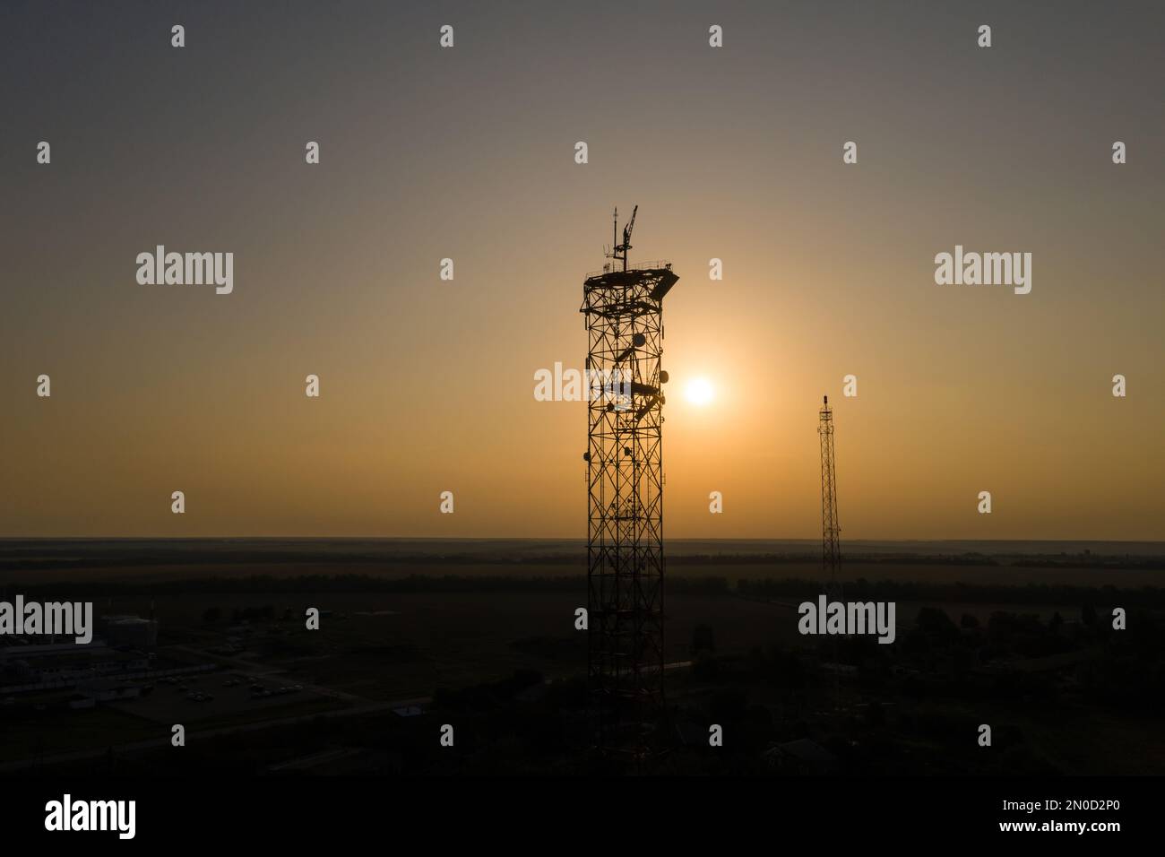 Die Sonne scheint durch die Silhouette der Telekommunikationstürme Stockfoto