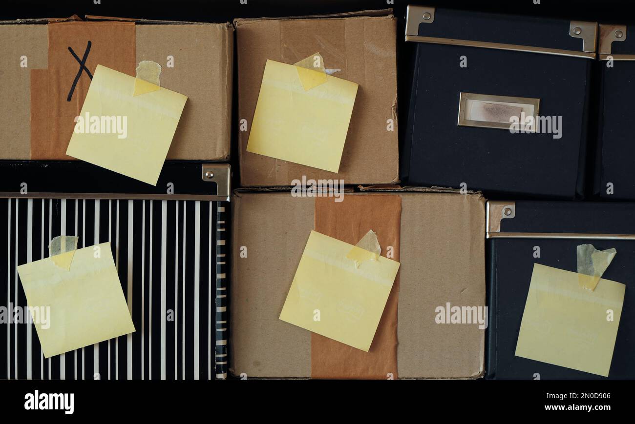 Verschiedene schmuddelige Pappkartons mit leeren, leeren Klebeetiketten, freier Platz für Kopien Stockfoto