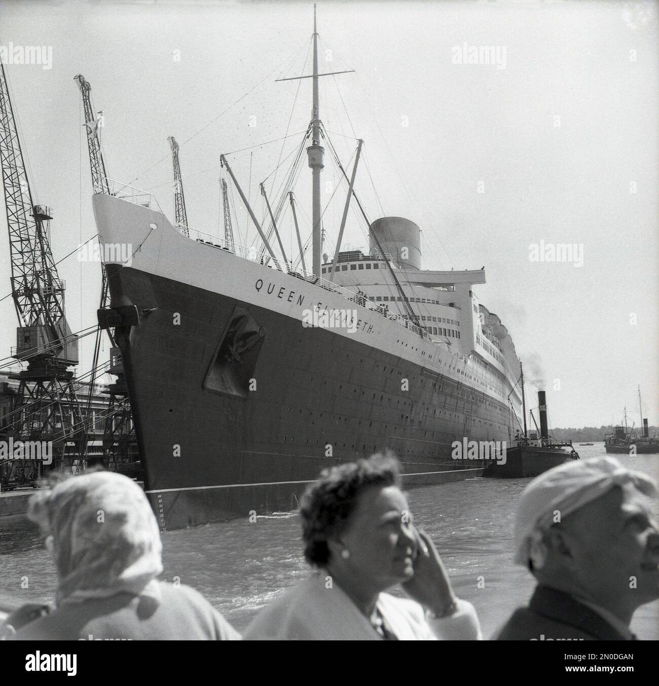 1950er, historisch, RMS Queen Elizabeth liegt an den Docks in Southampton, Hampshire, England, Großbritannien. Das luxuriöse Seeschiff wird von der Cunard Line betrieben und segelte wöchentlich von Southampton, England, nach New York, USA, über Cherbourg in Frankreich. Erbaut von John Brown & Co auf dem Clyde in Schottland, wurde sie zu Ehren von Königin Elizabeth, später Königin Mutter, benannt. Als sie 1938 gestartet wurde, war sie das größte Passagierschiff, das je gebaut wurde, bis 1994. Stockfoto