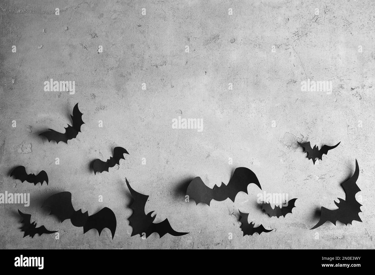 Papierschläger auf hellgrauem Hintergrund, flach liegend mit Platz für Text. Halloween-Dekor Stockfoto