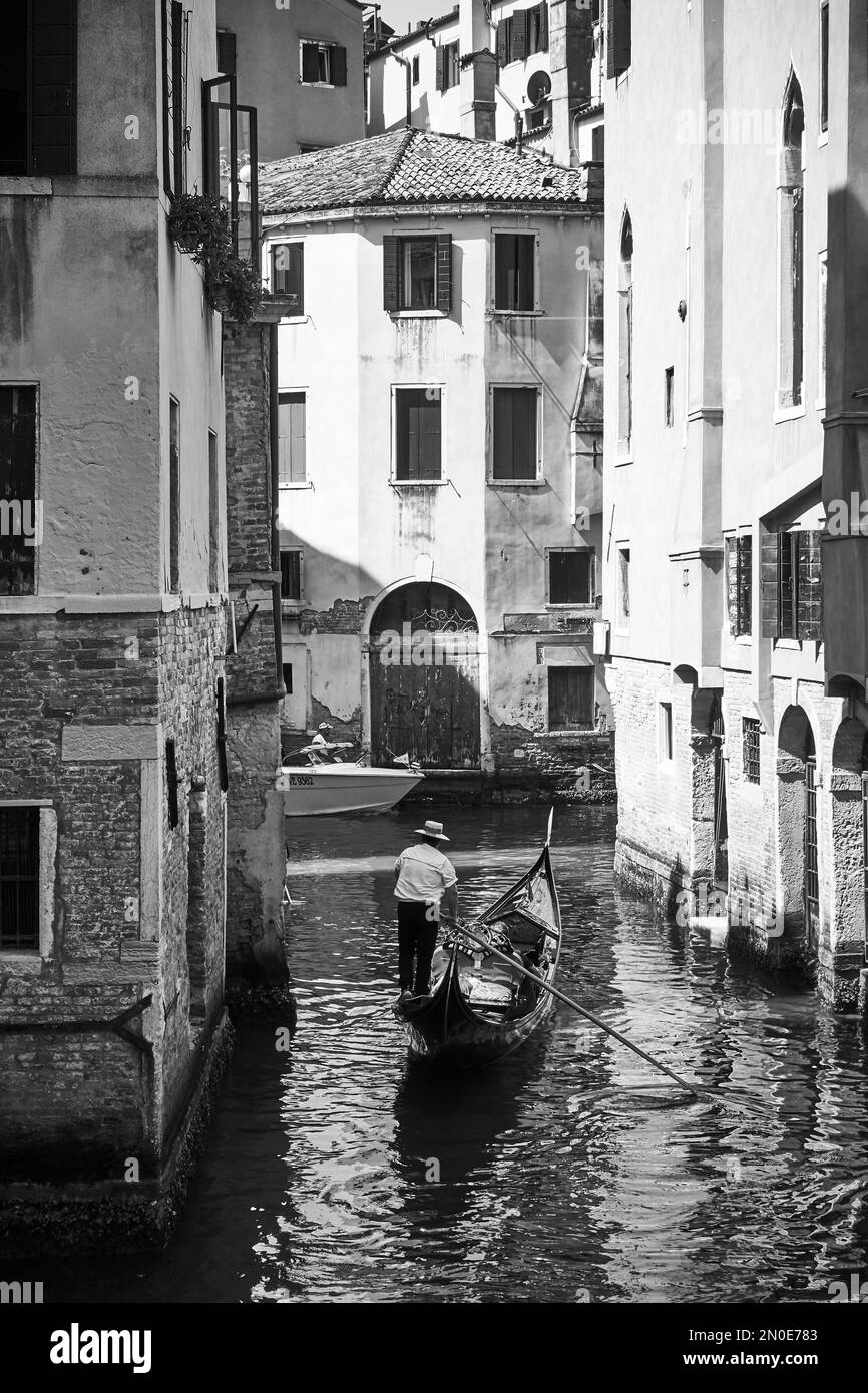 Venedig, Italien - 17. Juni 2018: Blick auf den venezianischen Kanal mit Gondel und Gondoliere. Schwarzweißfotografie Stockfoto