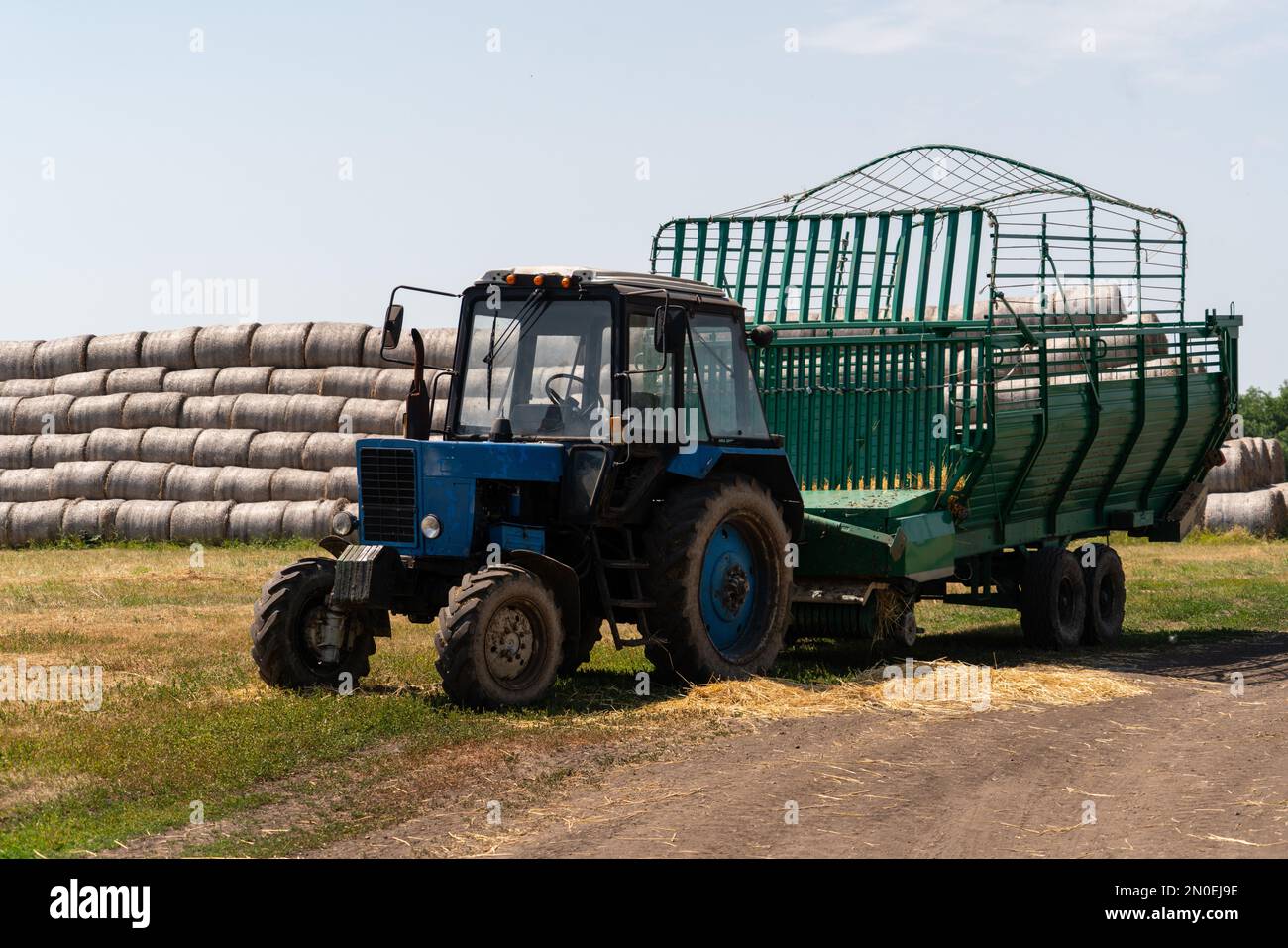 Landwirtschaftlicher Traktor auf dem Hintergrund von Strohballen Stockfoto