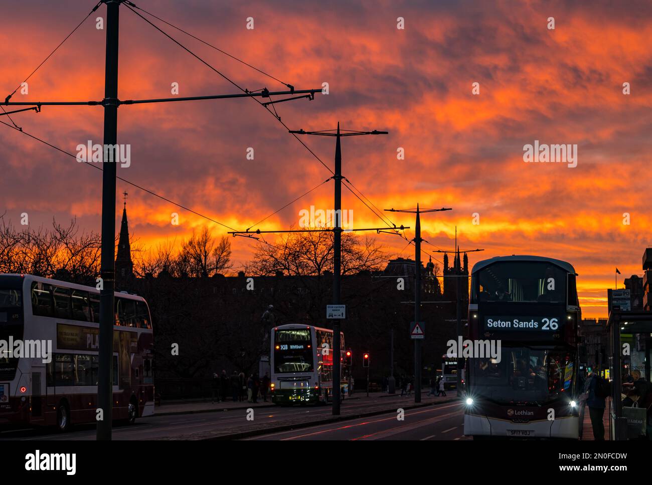 Edinburgh, Schottland, Vereinigtes Königreich, 5. Februar 2023. UK Weather dramatisch bunt feuriger Sonnenuntergang Himmel. Der Sonnenuntergang verwandelte den Himmel in leuchtende orangefarbene Farben, die über Bussen in der Princes Street zu sehen waren. Kredit: Sally Anderson/Alamy Live News Stockfoto
