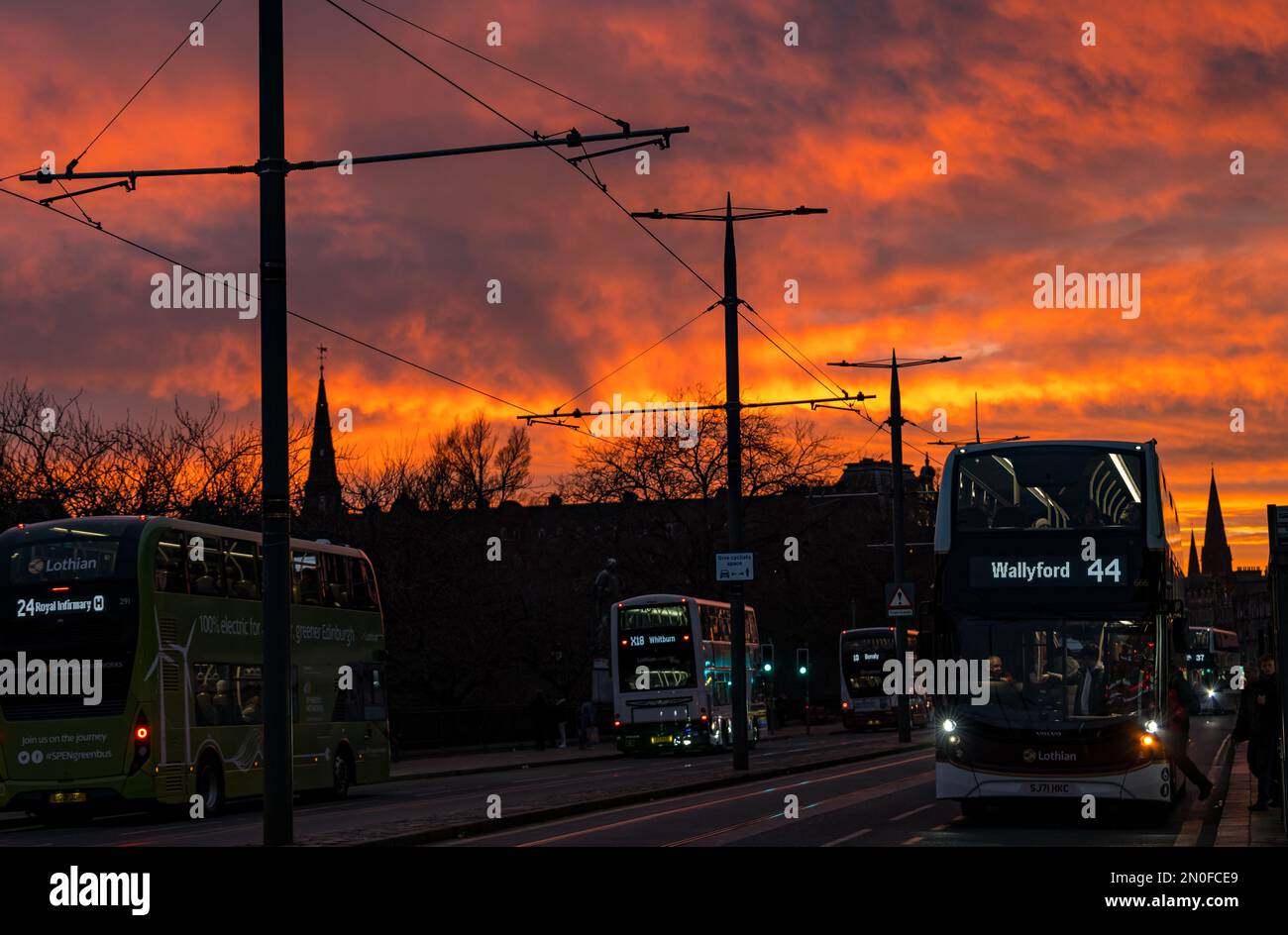 Edinburgh, Schottland, Vereinigtes Königreich, 5. Februar 2023. UK Weather dramatisch bunt feuriger Sonnenuntergang Himmel. Der Sonnenuntergang verwandelte den Himmel in leuchtende orangefarbene Farben, die über Bussen in der Princes Street zu sehen waren. Kredit: Sally Anderson/Alamy Live News Stockfoto