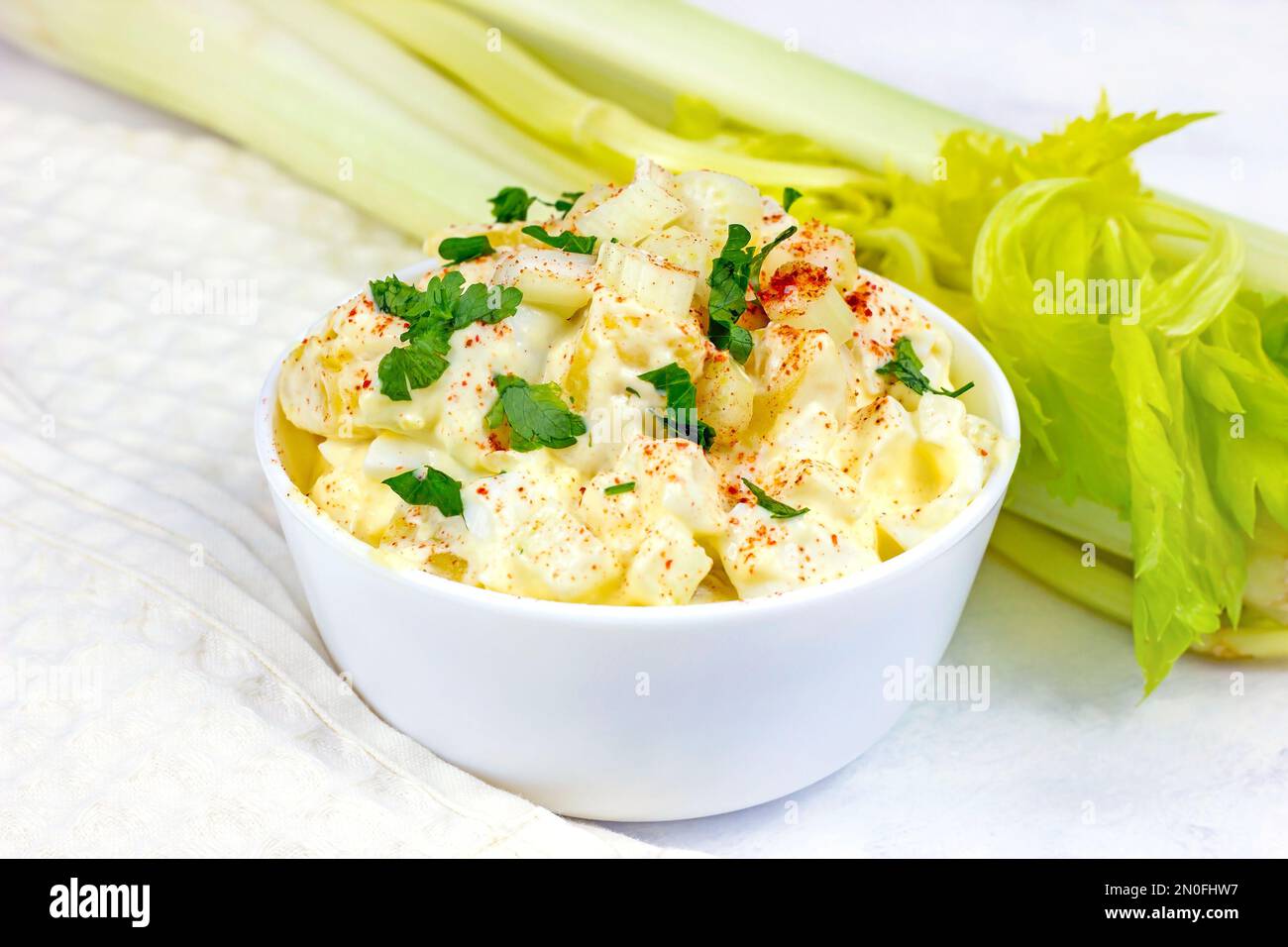 Frischer, hausgemachter traditioneller Amish-Kartoffelsalat mit Kartoffeln, gekochten Eiern, cremigem Dressing und Sellerie in einer weißen Schüssel, fertig zum Abendessen. Stockfoto
