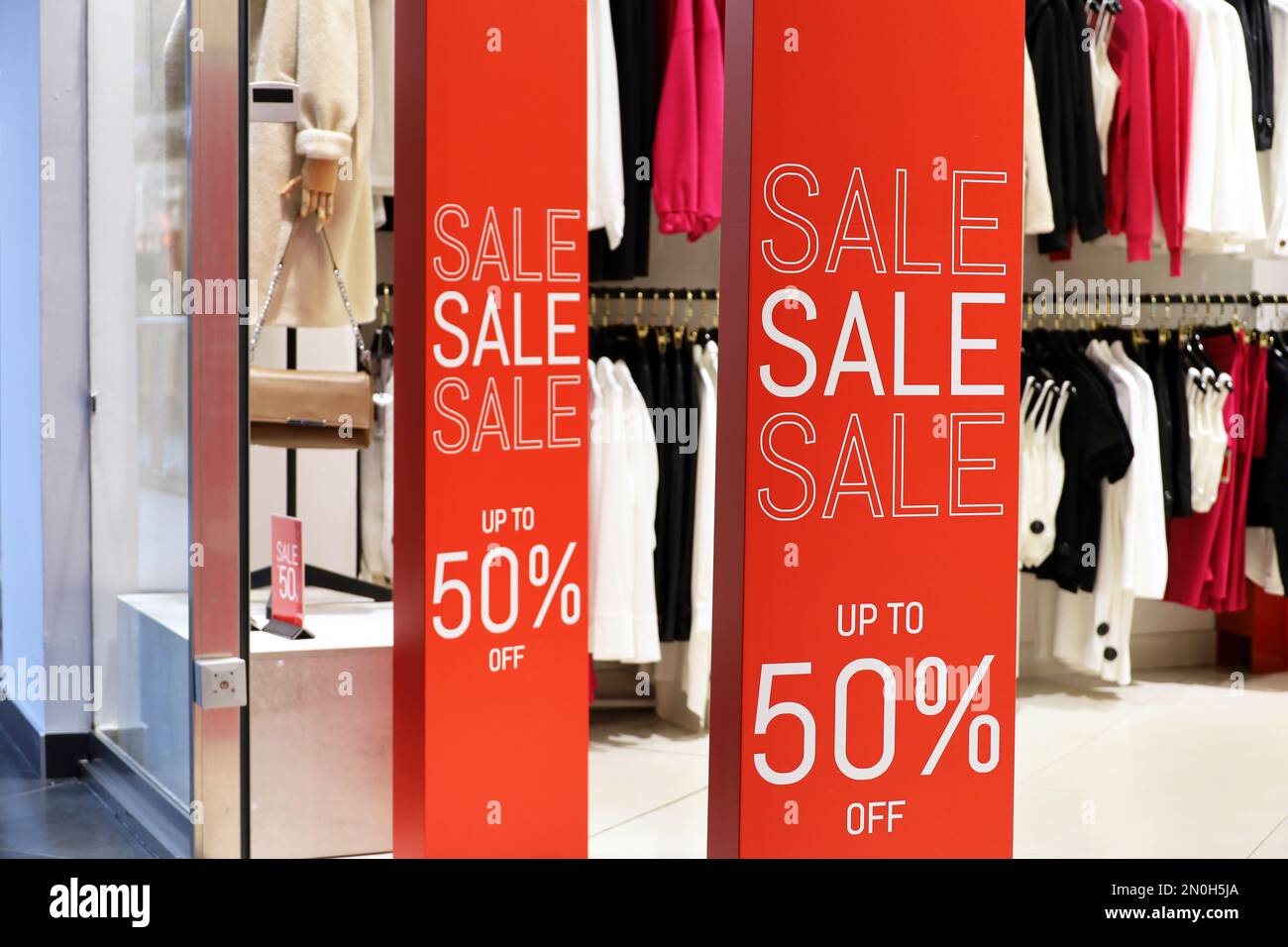 Verkaufsschilder mit unterschiedlichen Rabatten in einem Bekleidungsgeschäft. Konzept des Einzelhandels und des Einkaufs Stockfoto