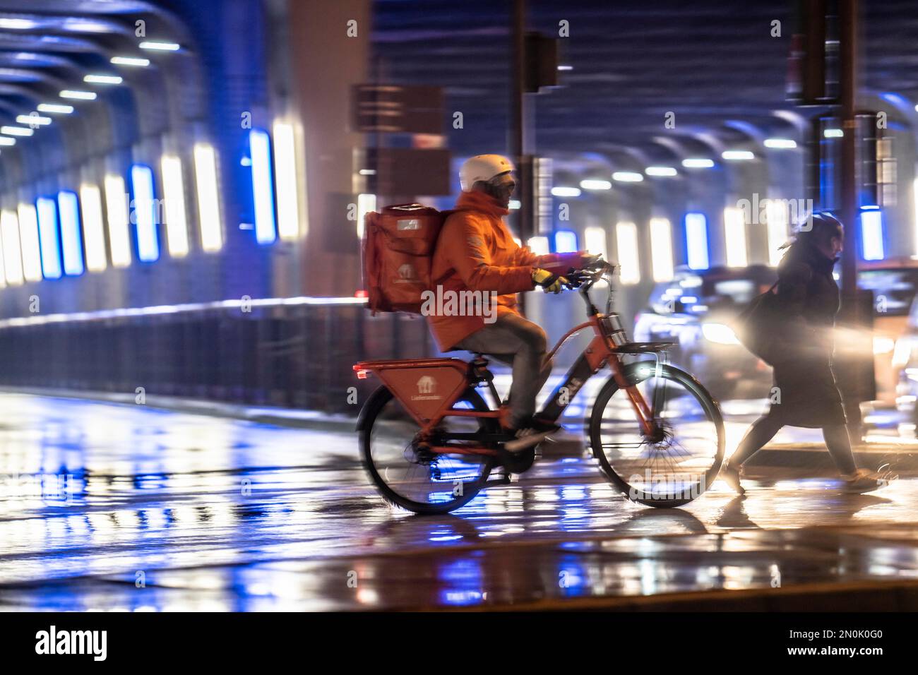 Straße am Hauptbahnhof, Lieferando Kurier, Radfahrer, Regenwetter, Stadtzentrum, Am Abend essen, NRW, Deutschland, Stockfoto