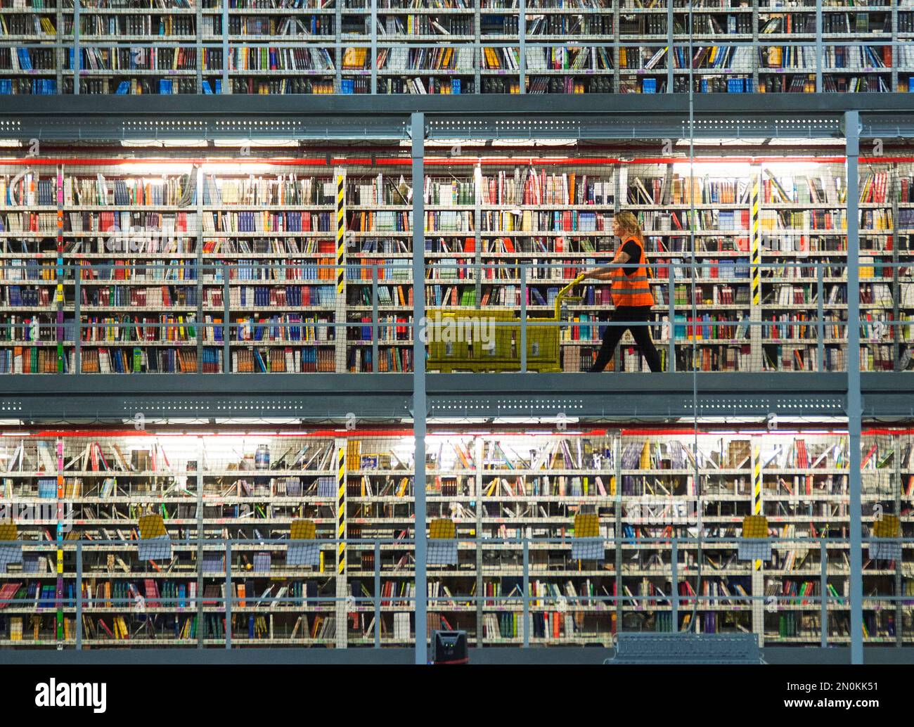 FILE - In this Nov. 19, 2015 file photo an employee works in the distribution center of the online retailer Amazon in Leipzig, central Germany. Amazon has pledged to donate its share of revenues from the sale of a song by the anti-Islam group PEGIDA (Patriotic Europeans against the Islamization of the West) to refugees, undermining the cause of the far-right movement. (AP Photo/Jens Meyer, file) Stockfoto