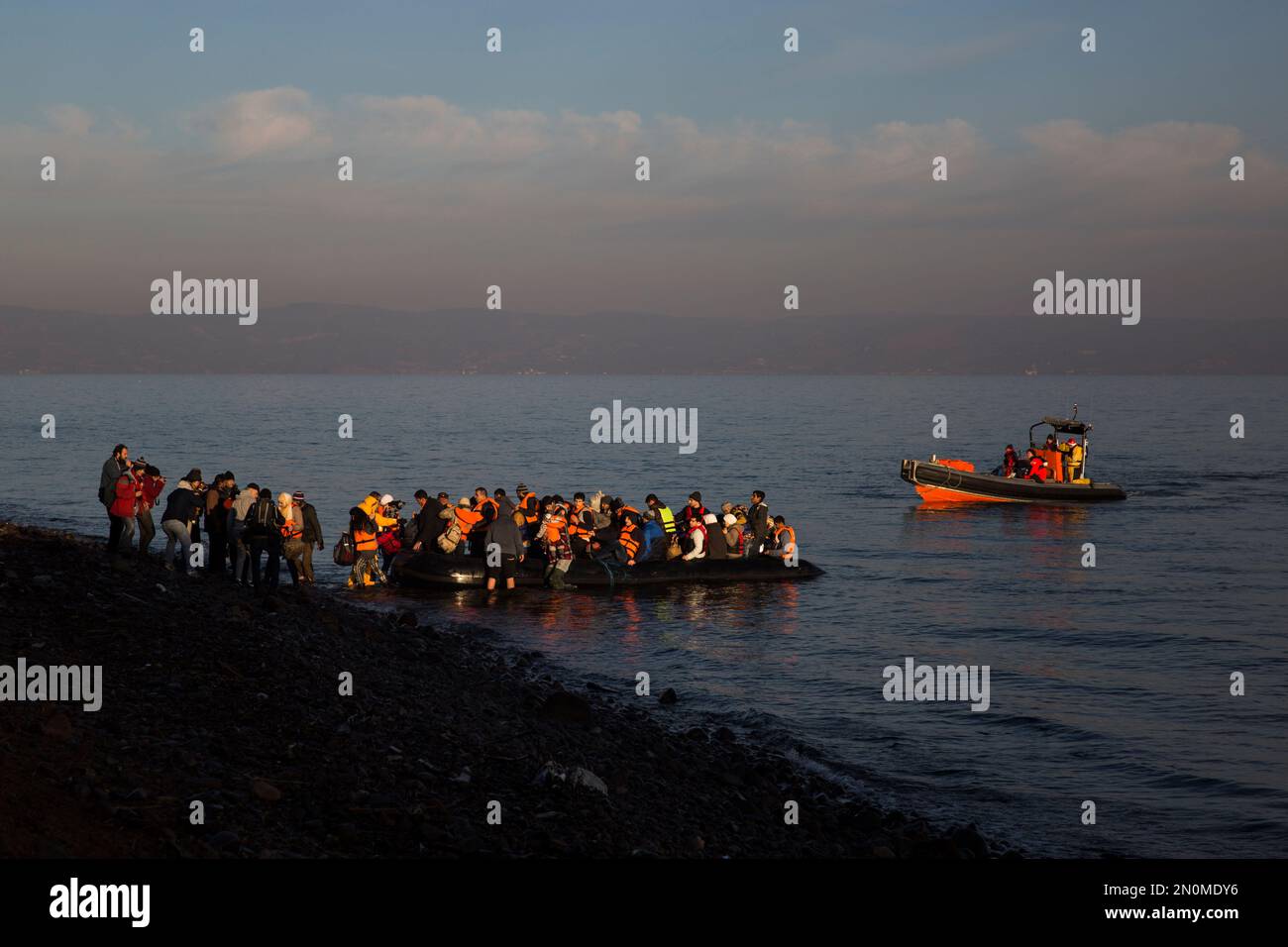 Refugees and migrants disembark from a dinghy on a beach after crossing a part of the Aegean sea from the Turkey's coast to the northeastern Greek island of Lesbos, on Friday, Dec. 25, 2015. The International Organization for Migrants said more than 1 million people have entered Europe earlier this week. Almost all came by sea, while 3,692 drowned in the attempt. (AP Photo/Santi Palacios) Stockfoto