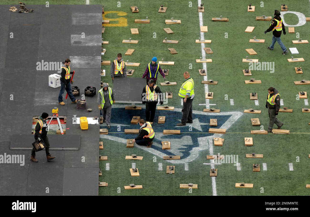 Workers install a portion of an NHL hockey rink near a New England