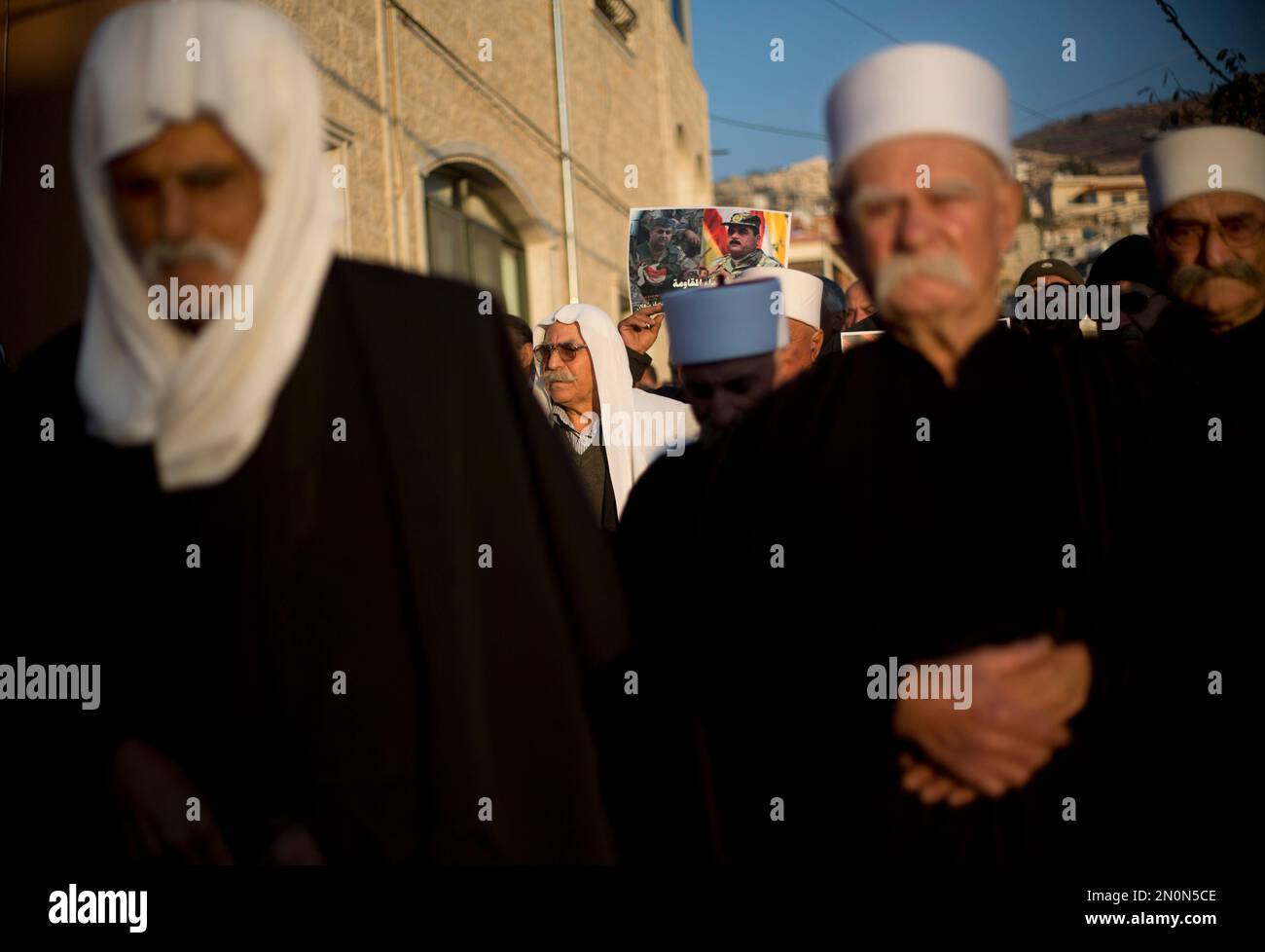 Druze men hold photographs of Farhan alShaalan and Samir Kantar, who