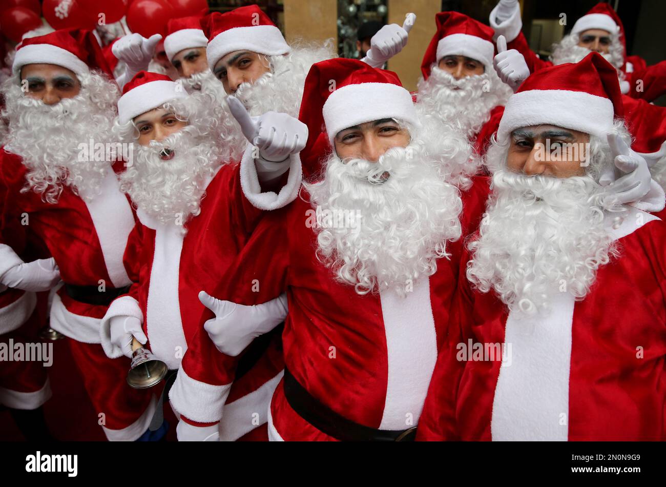 Lebanese men and women wearing Santa Claus costumes enjoy a parade during a Christmas event, in downtown Beirut, Lebanon, Saturday, Dec. 19, 2015. (AP Photo/Hussein Malla) Stockfoto