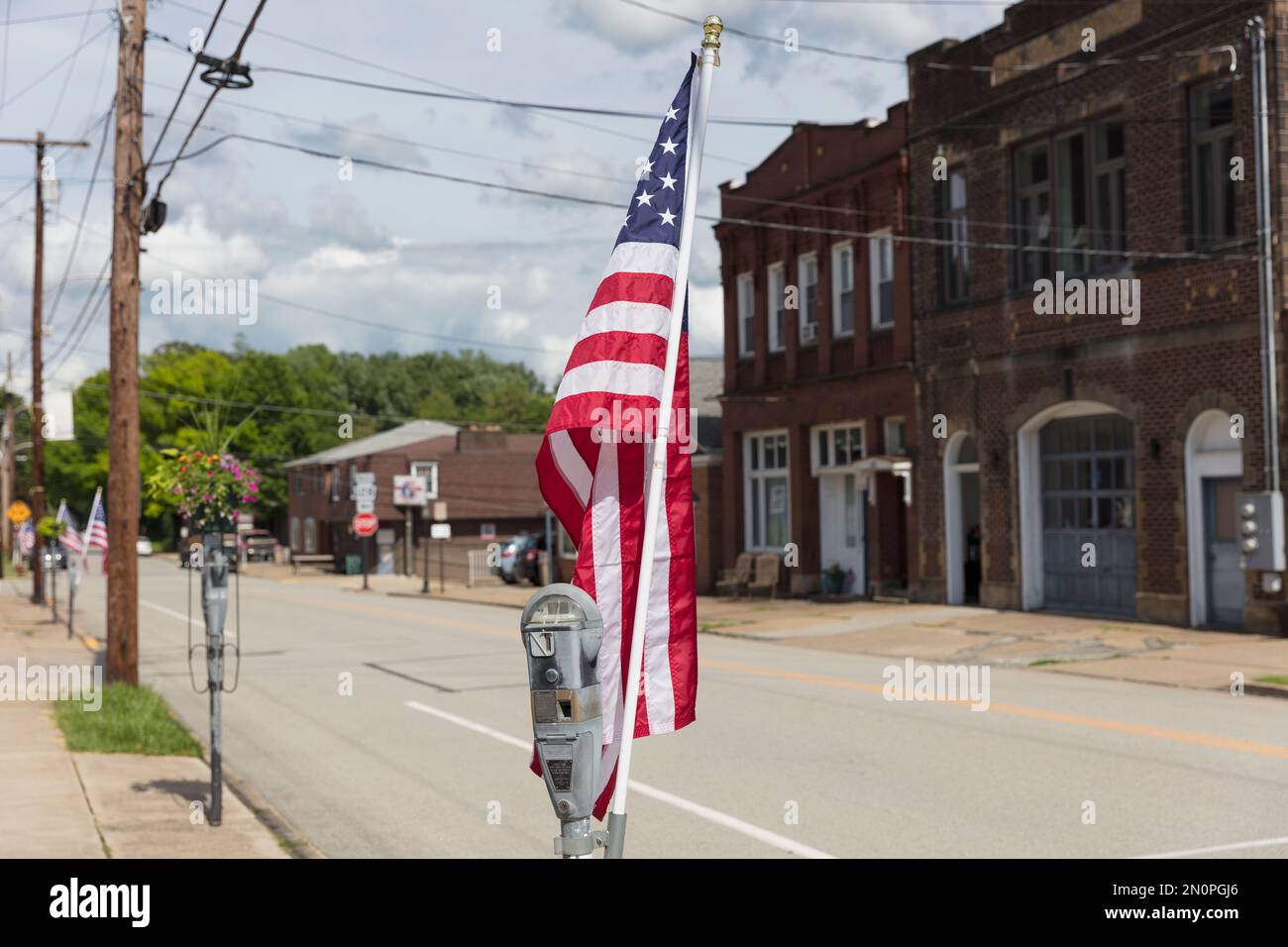 Die amerikanische Flagge flattert in der Brise auf einer verlassenen Hauptstraße. Stockfoto