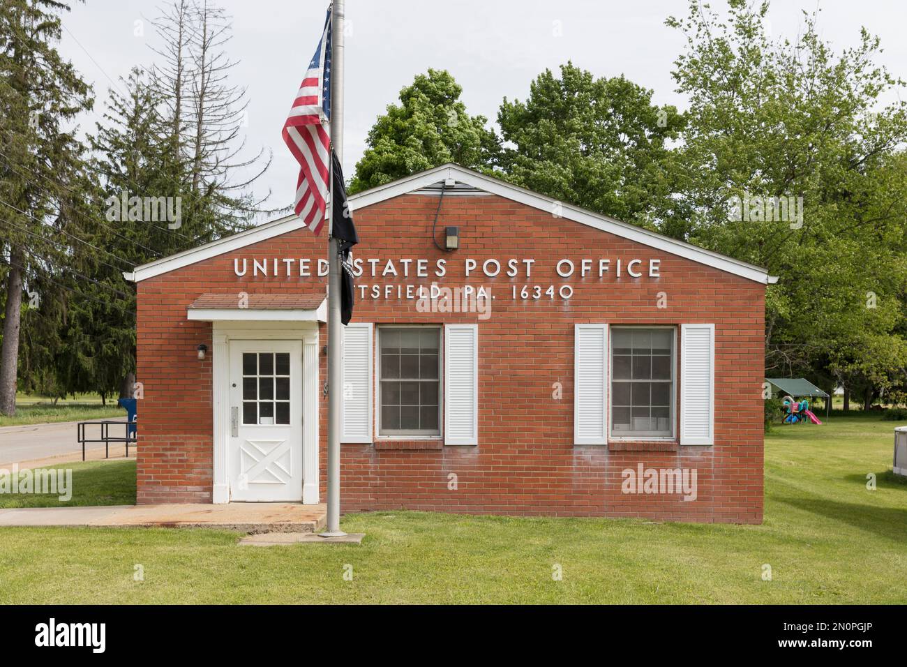 Ländliches US-Postgebäude, mit amerikanischer Flagge. Stockfoto