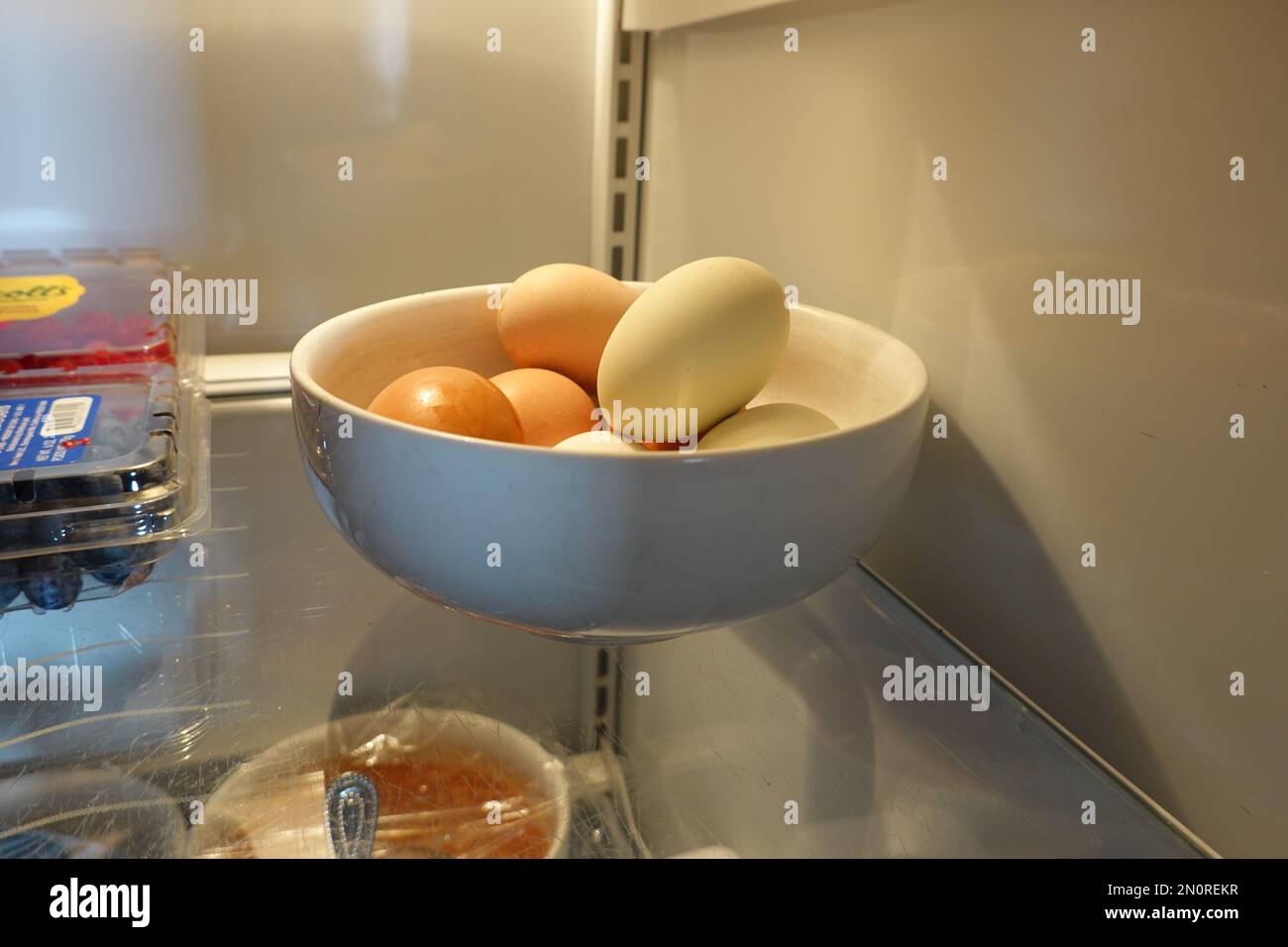 Schüssel mit frischen Hühnereiern aus Freilandhaltung im Kühlschrank Stockfoto